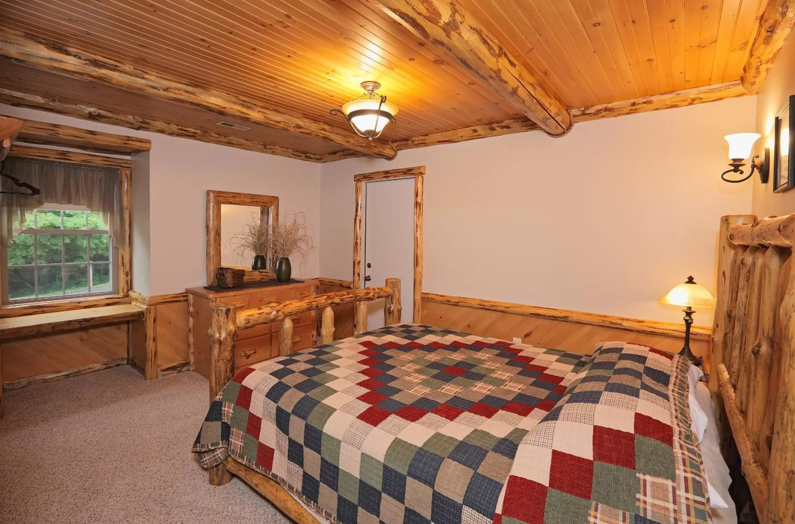 Bed in Sojourner's Lodge & Log Cabin Suites