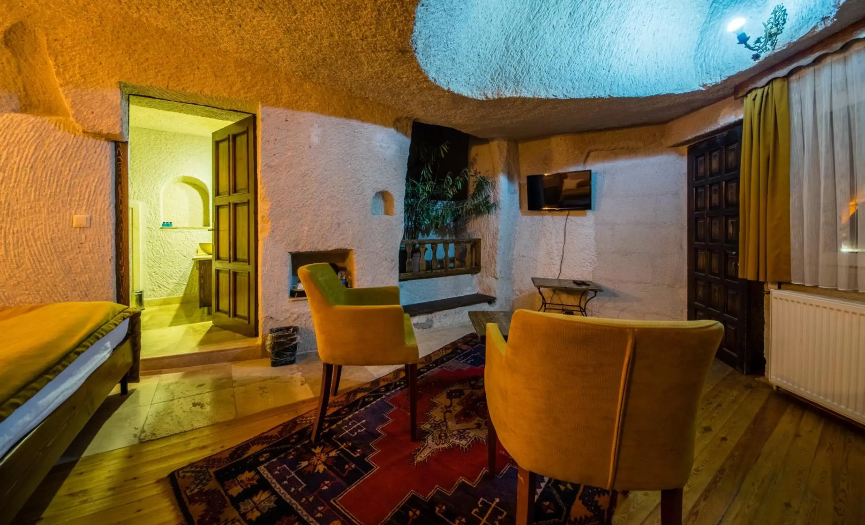 Bed, Seating Area in Elite Cave Suites