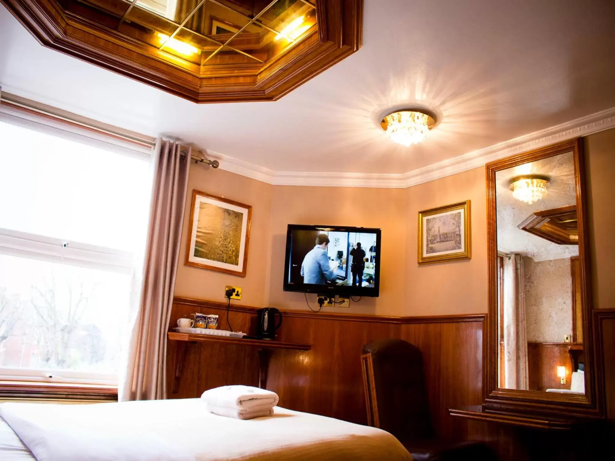 Bedroom, TV/Entertainment Center in Cricklewood Lodge Hotel
