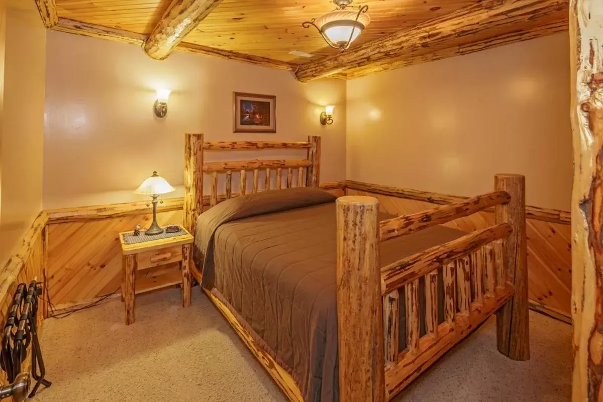 Bed in Sojourner's Lodge & Log Cabin Suites