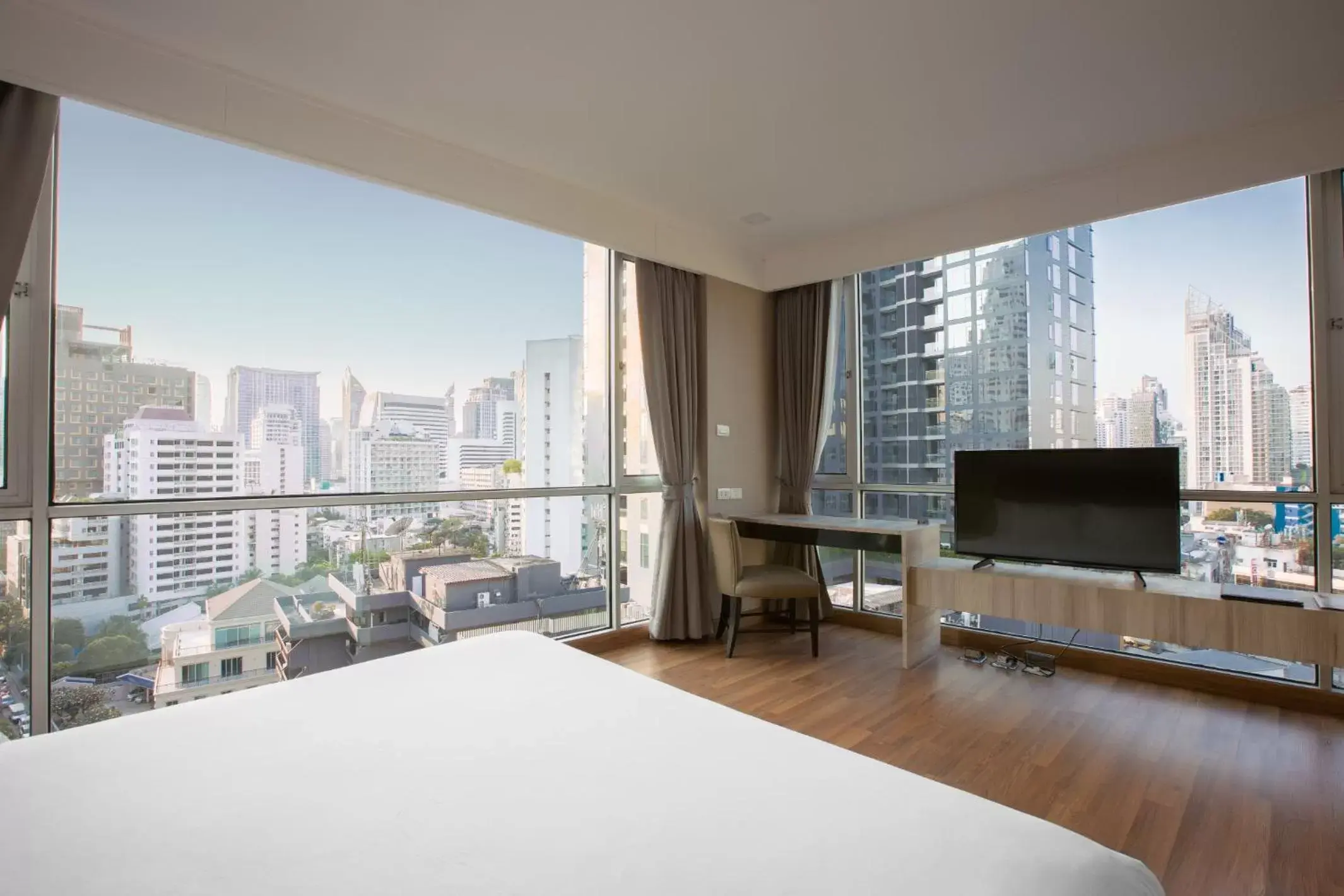 Bed, TV/Entertainment Center in Adelphi Suites Bangkok - SHA Extra Plus