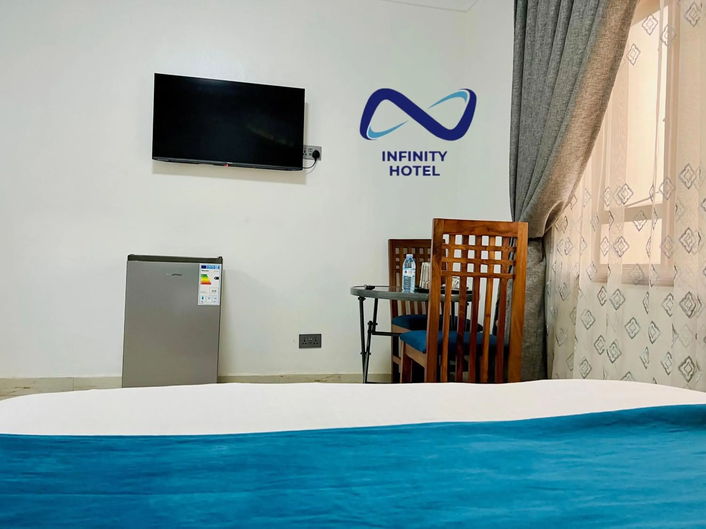 Bed, TV/Entertainment Center in Infinity Hotel Kampala