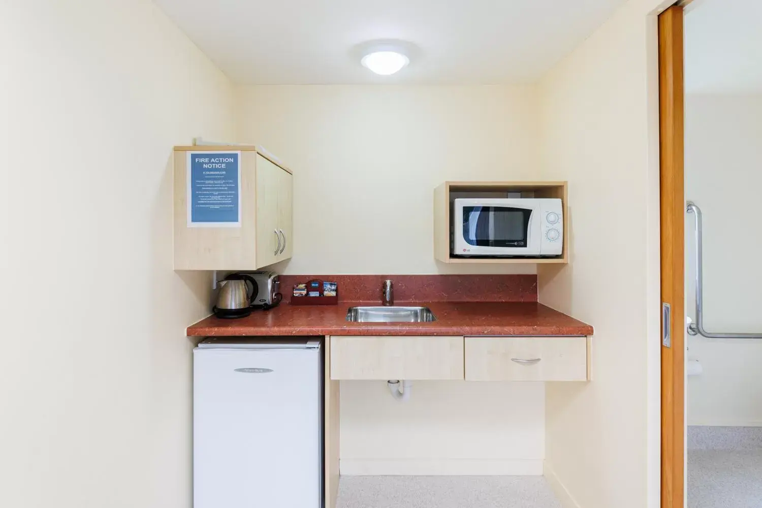 Kitchen or kitchenette, TV/Entertainment Center in Bella Vista Motel Palmerston North