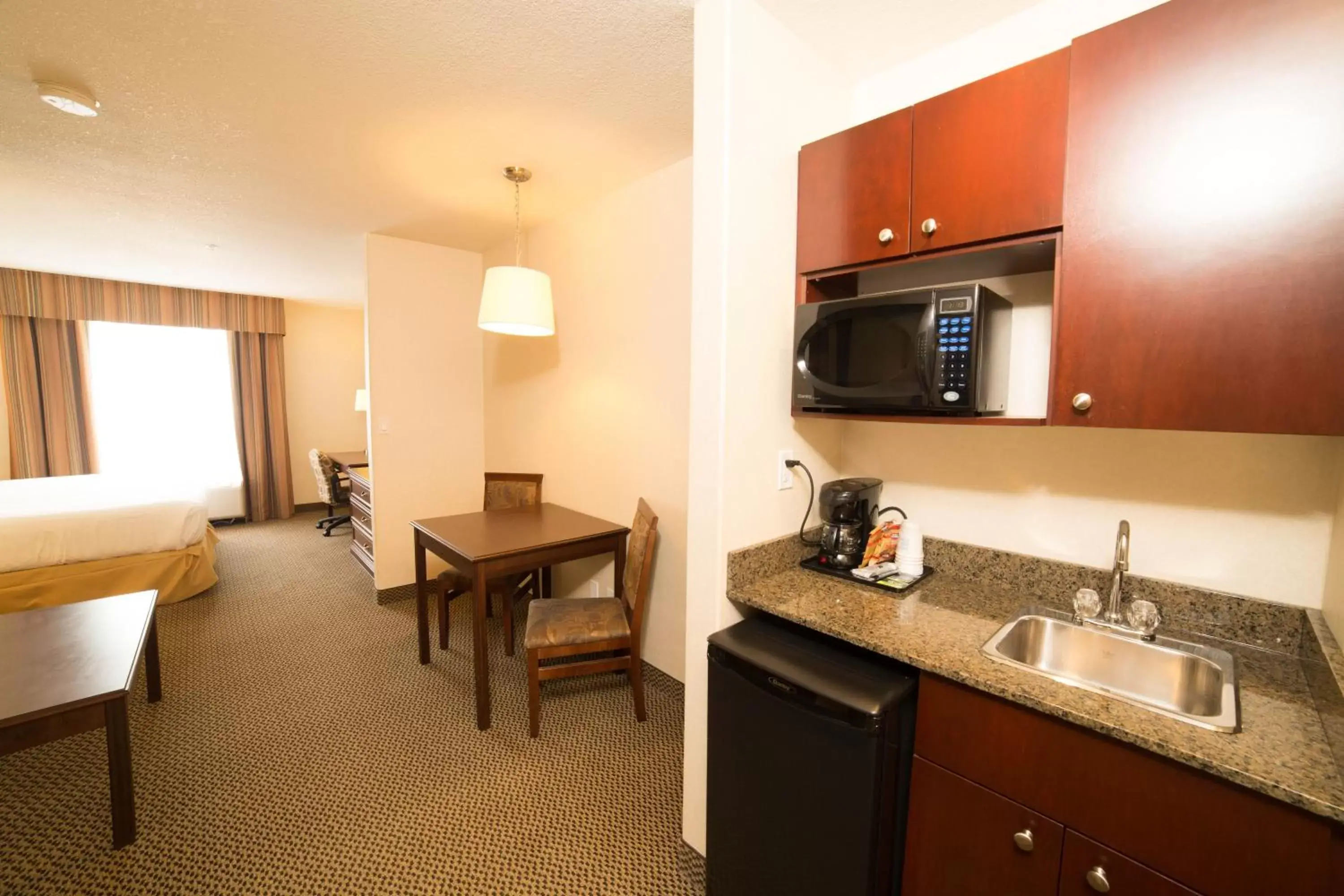 Bedroom, Kitchen/Kitchenette in Holiday Inn Express Hotel & Suites - Slave Lake, an IHG Hotel