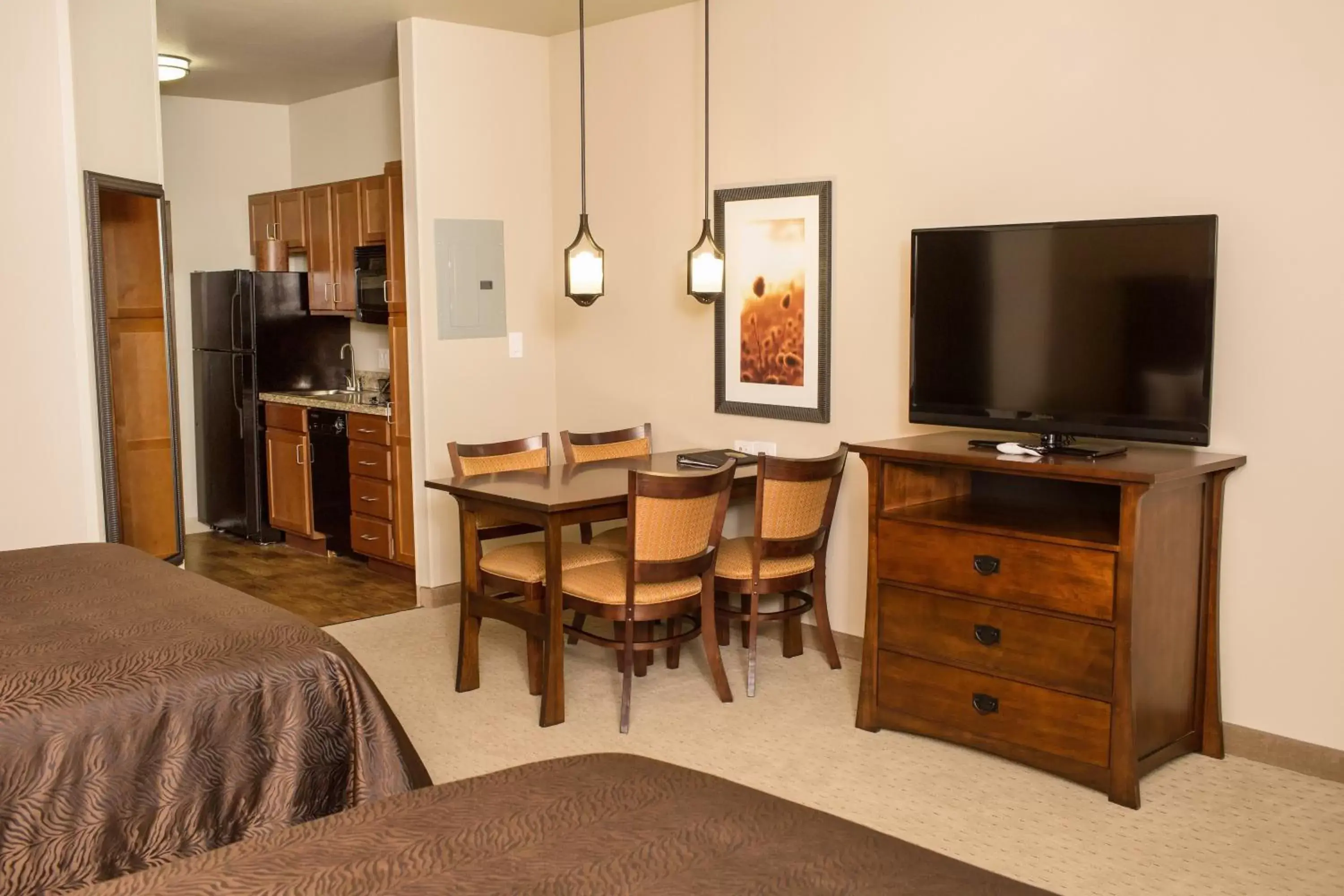 Dining area, TV/Entertainment Center in Teddy's Residential Suites Watford City