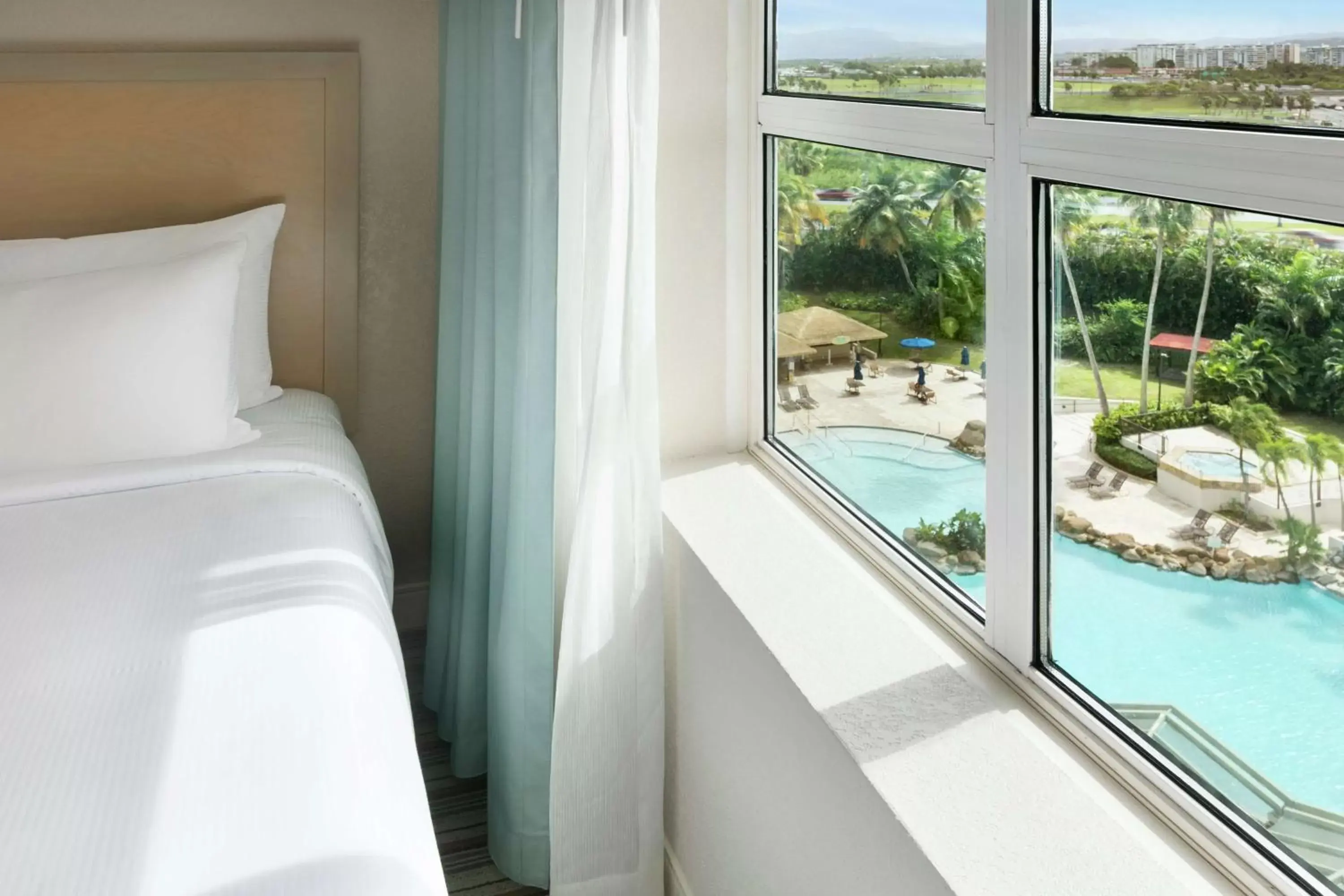 Bed, Pool View in Embassy Suites by Hilton San Juan - Hotel & Casino