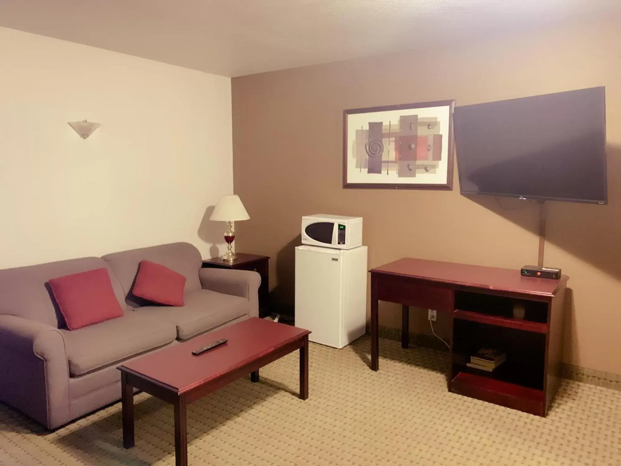 Living room, TV/Entertainment Center in Ramada by Wyndham Red Deer Hotel & Suites