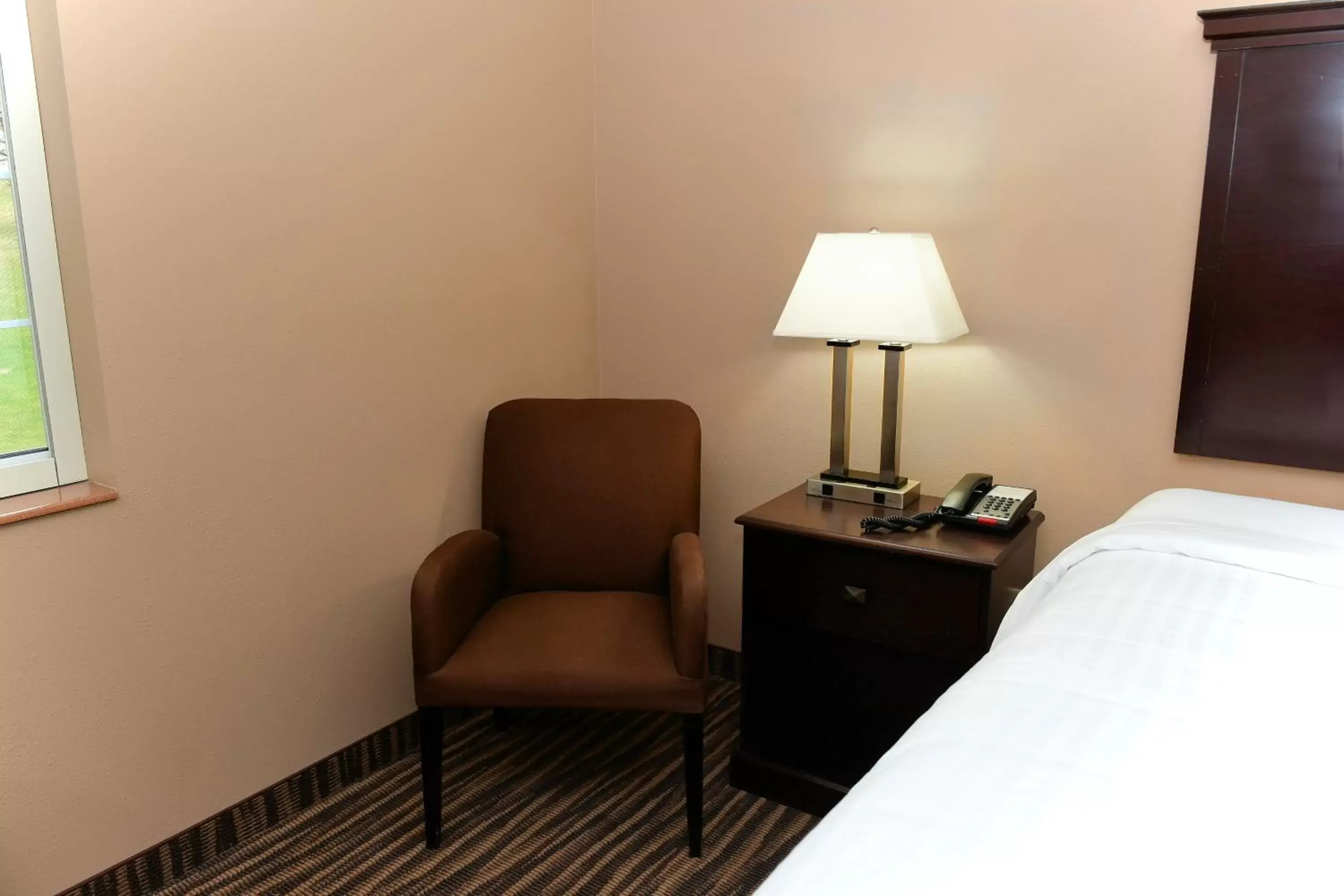 Bed, Seating Area in Cobblestone Inn & Suites - Denison | Majestic Hills