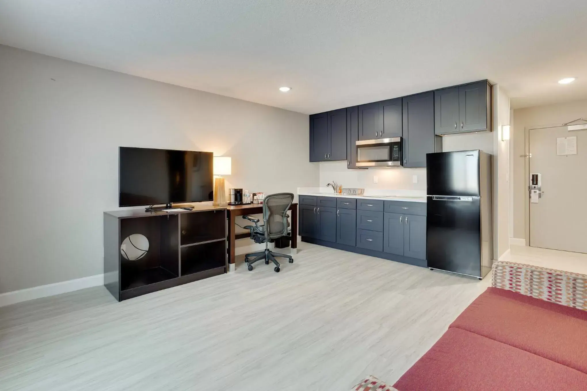 Living room, Kitchen/Kitchenette in Orangewood Inn & Suites Kansas City Airport