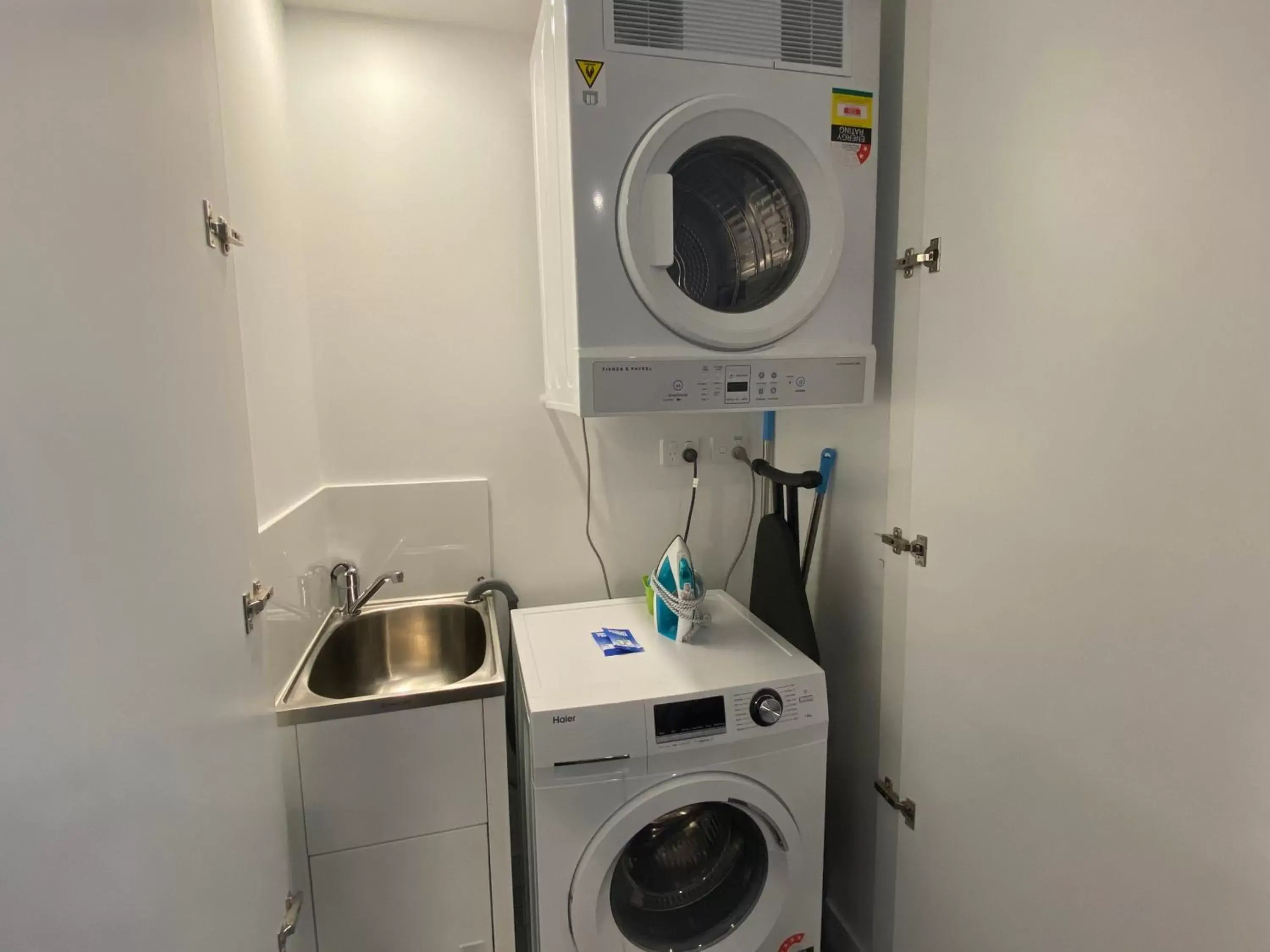 washing machine, Kitchen/Kitchenette in Brisbane One Apartments by CLLIX