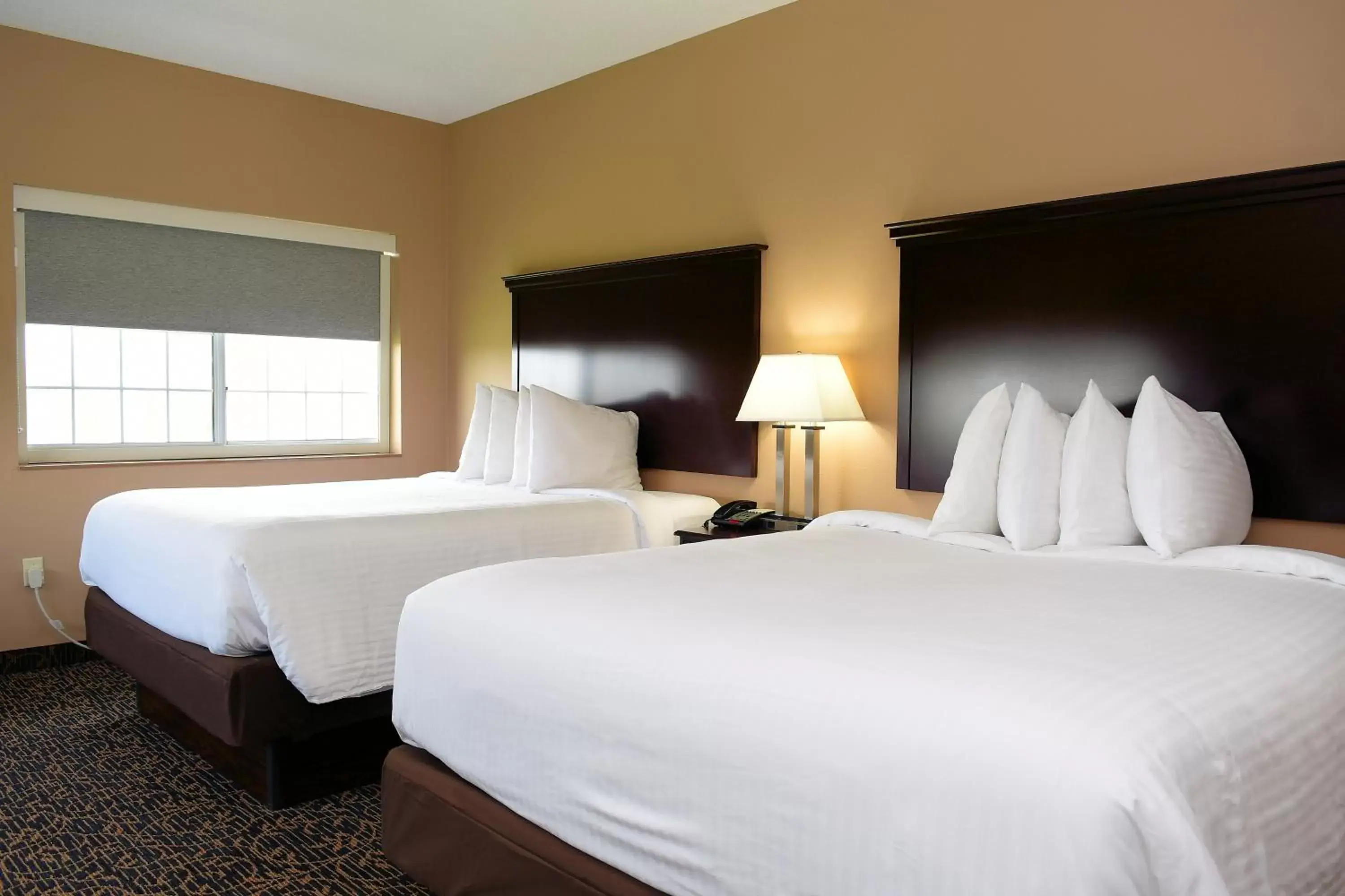 Bed in Cobblestone Inn & Suites - Denison | Majestic Hills