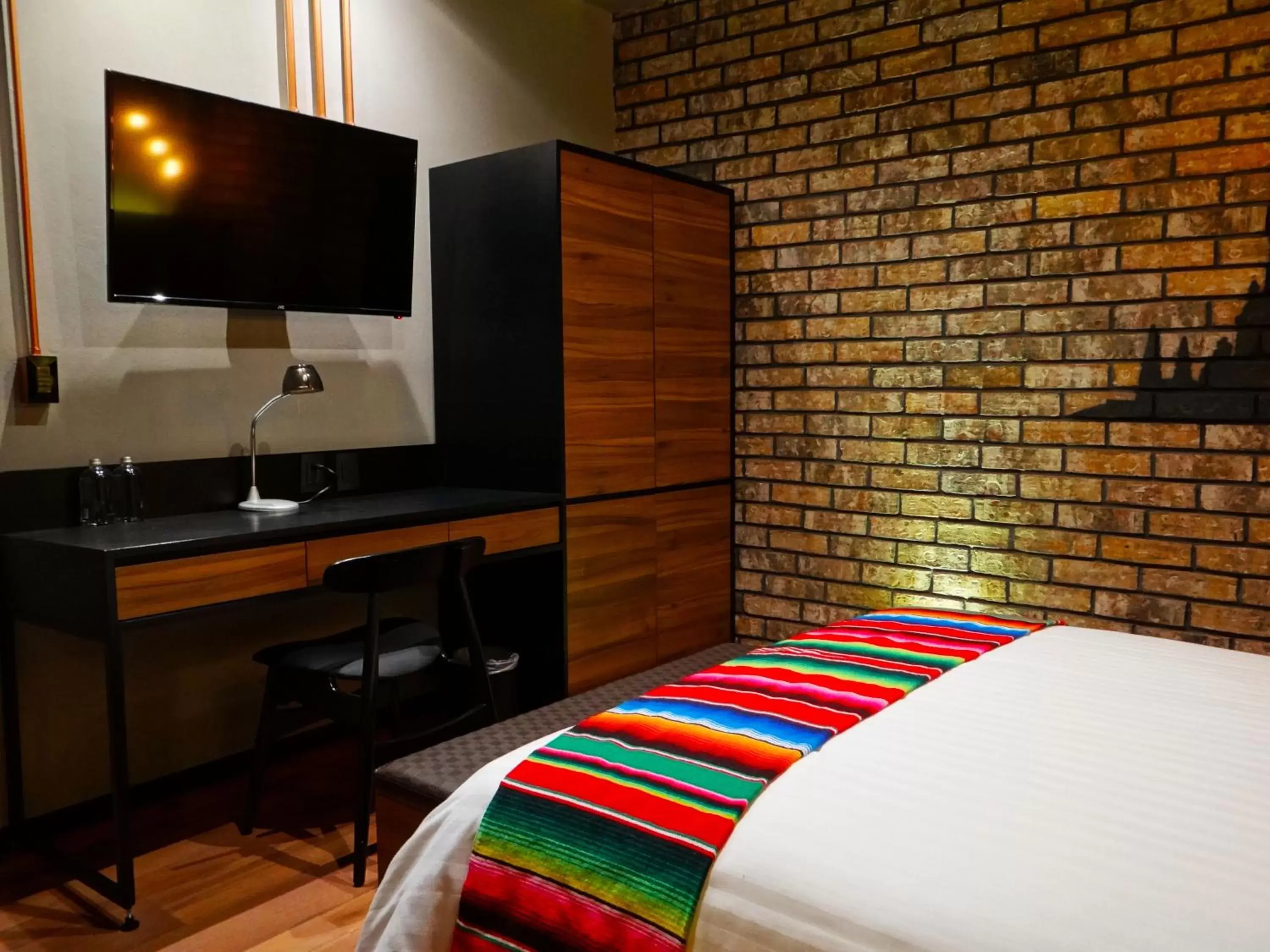 Bed, TV/Entertainment Center in Cadillac Hotel Boutique