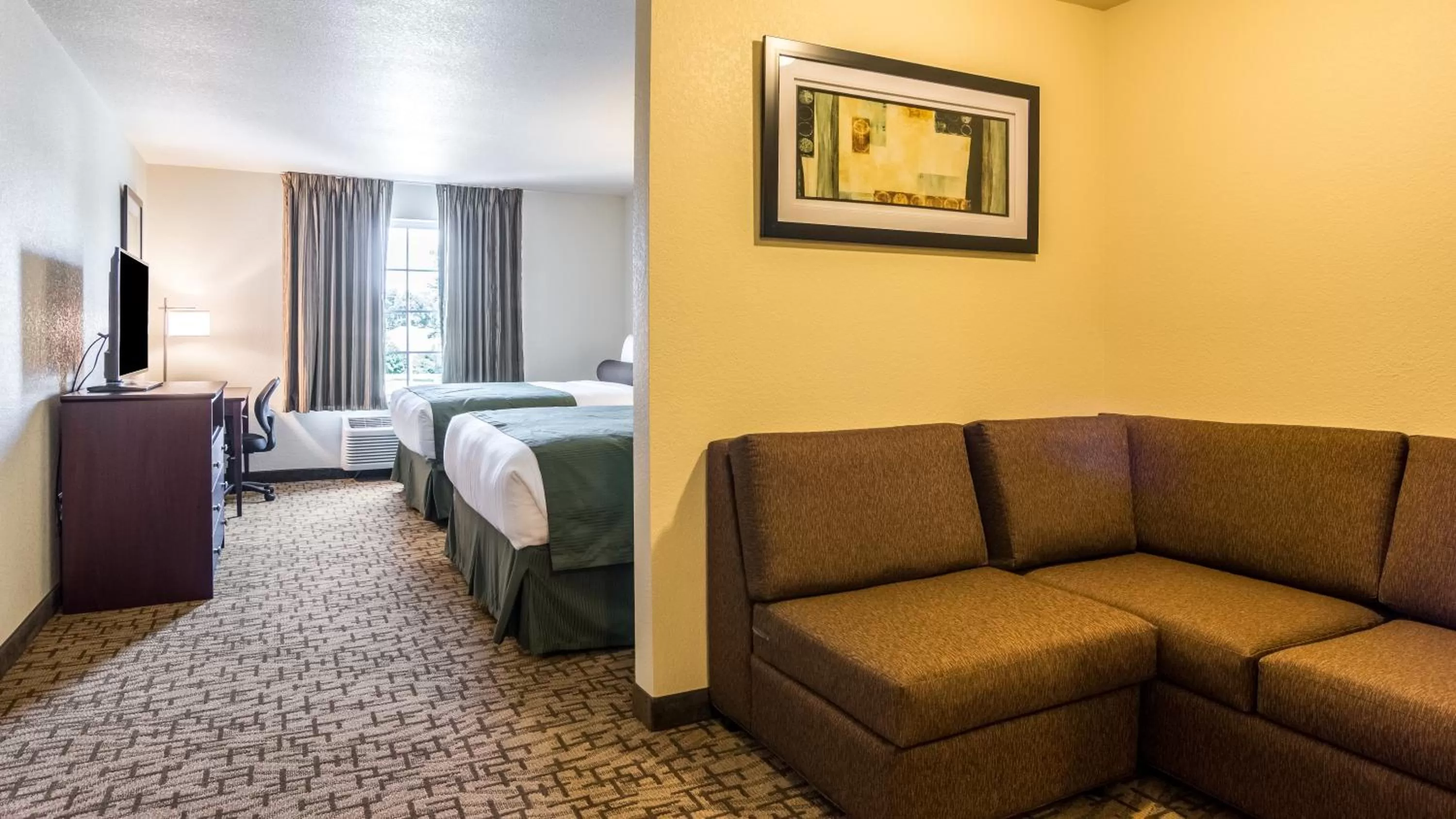 Seating area, Bed in Cobblestone Hotel & Suites - Greenville