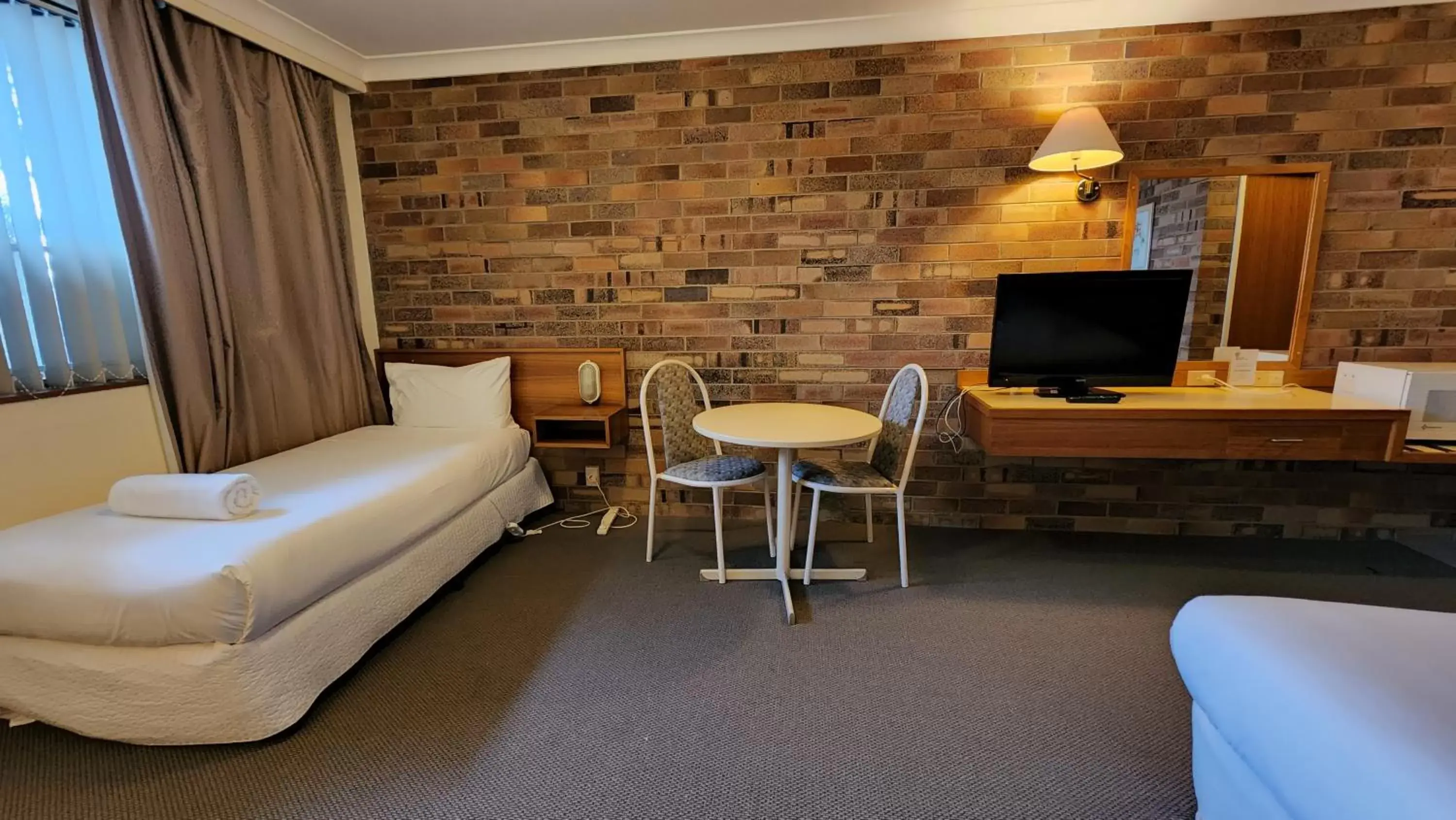 Bedroom, TV/Entertainment Center in All Seasons Motel Armidale