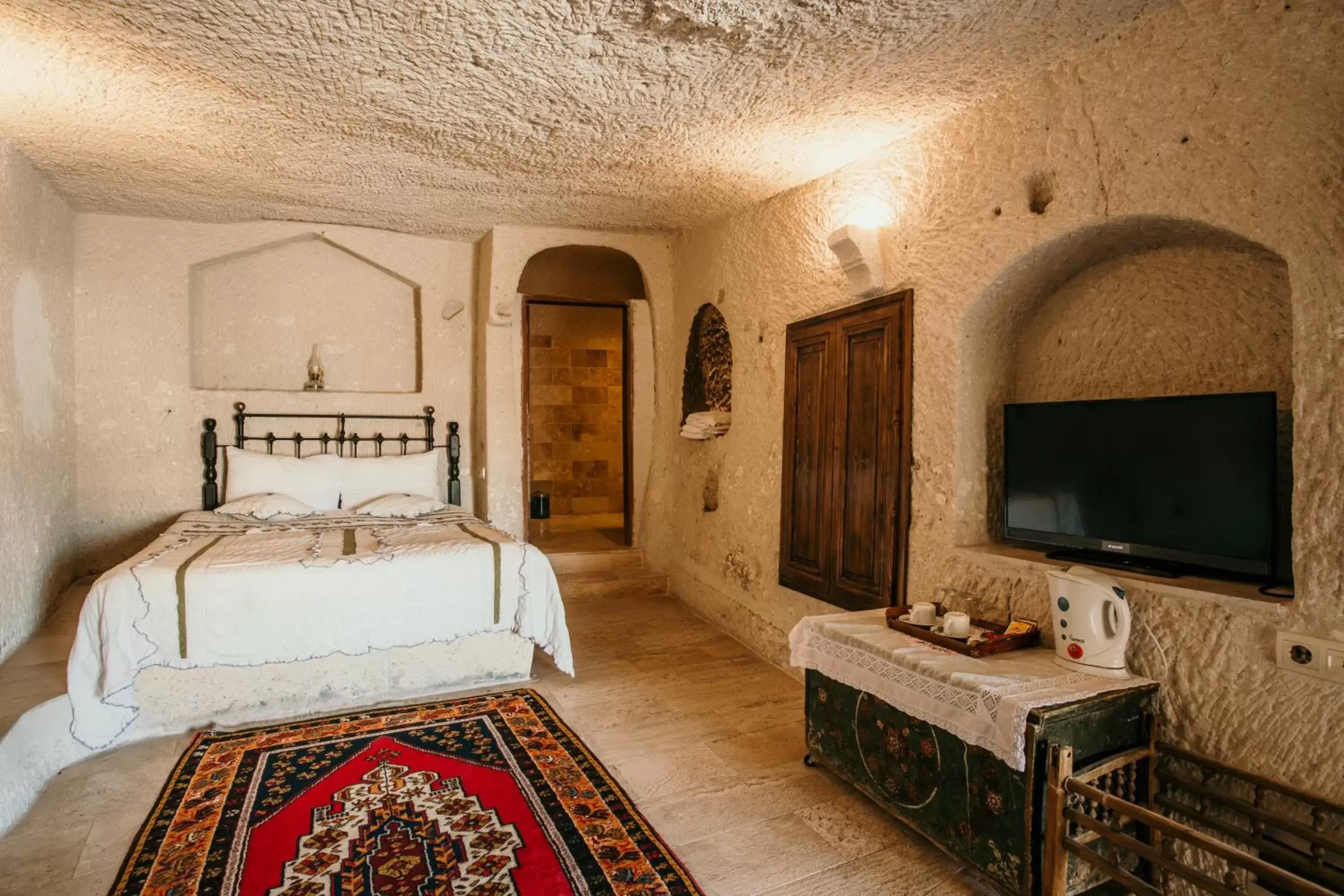 Bed, TV/Entertainment Center in Village Cave House Hotel