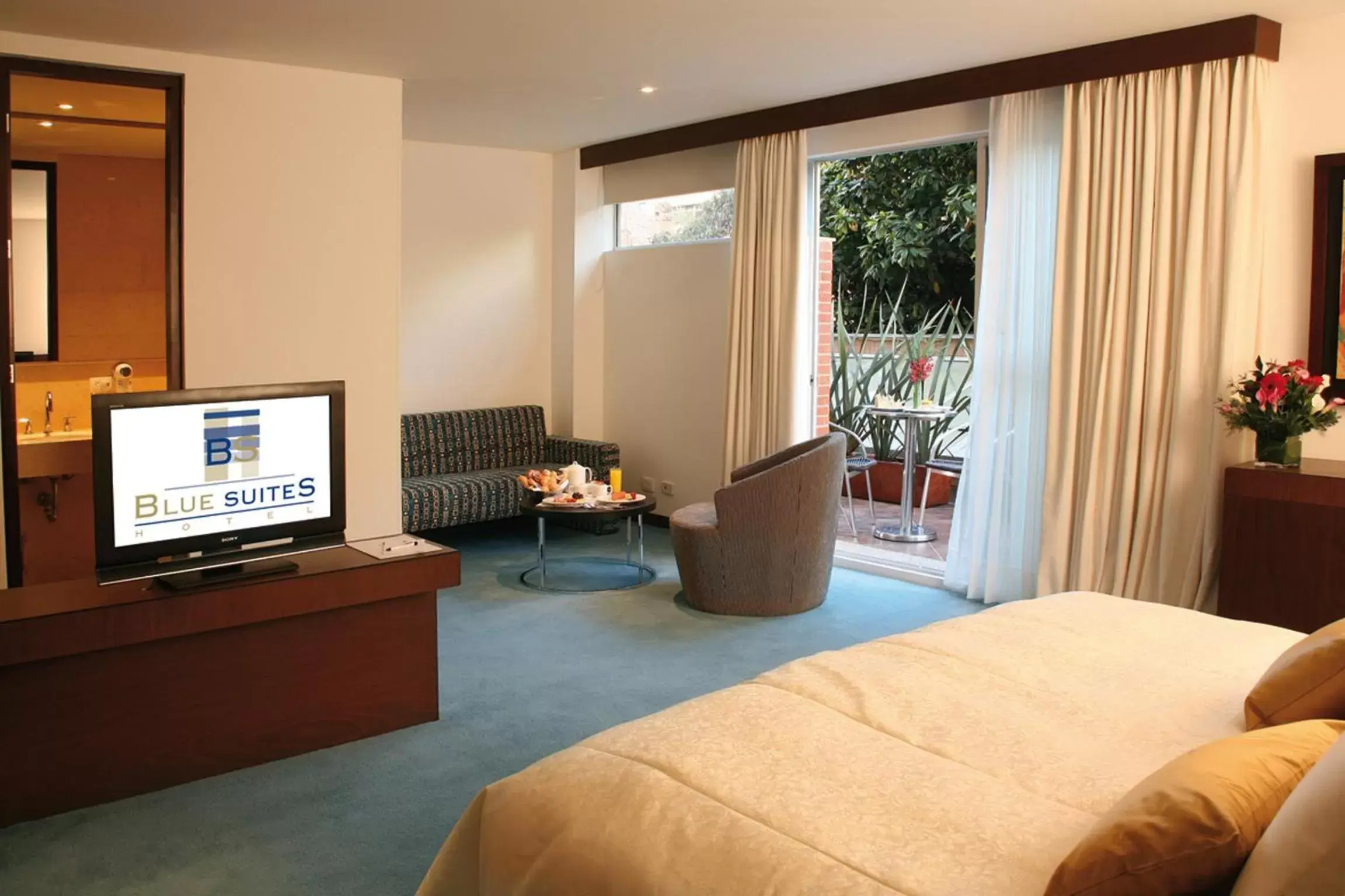 Bed, TV/Entertainment Center in Blue Suites Hotel