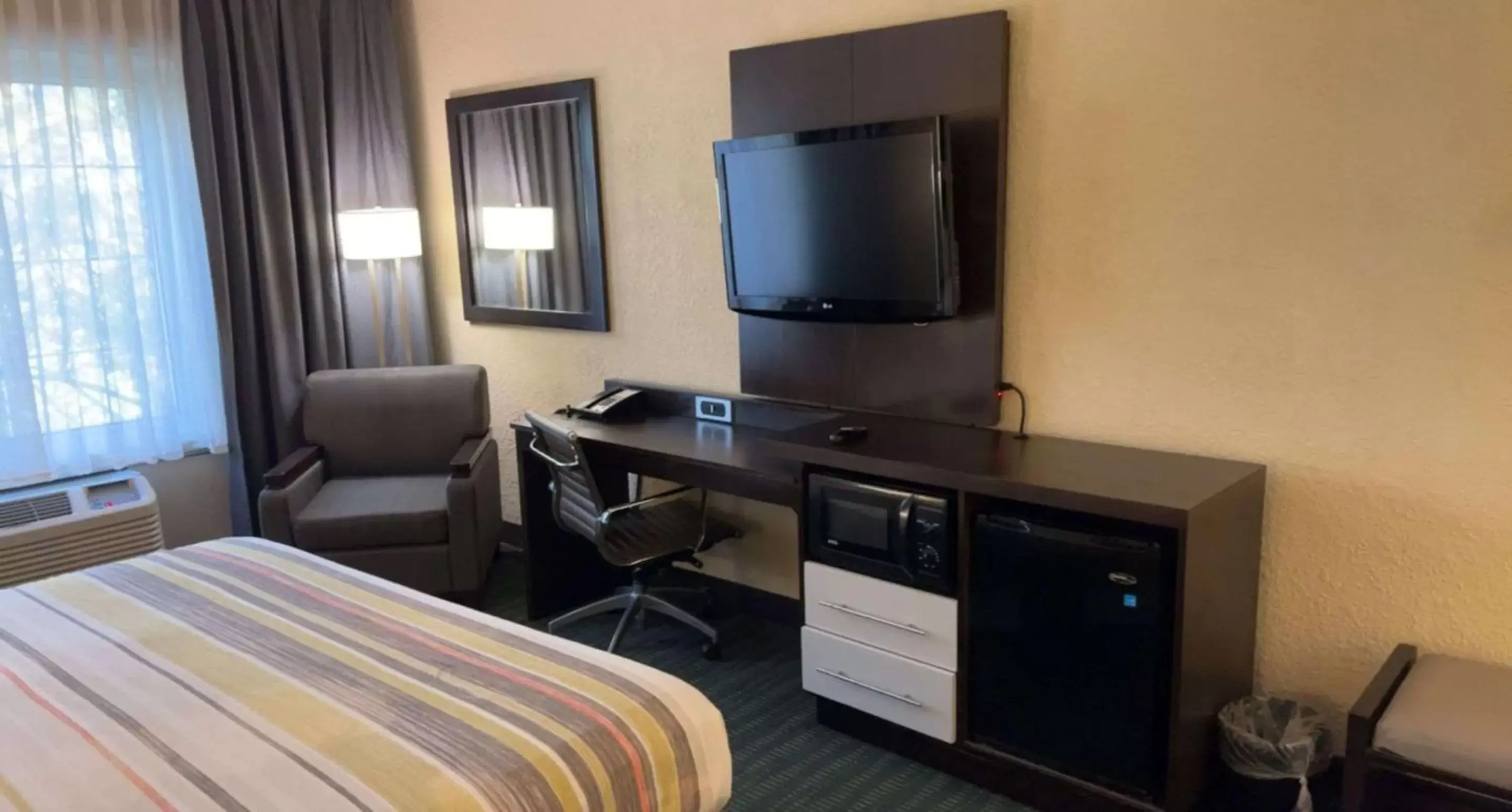 Bedroom, TV/Entertainment Center in SureStay Plus Hotel by Best Western Vero Beach