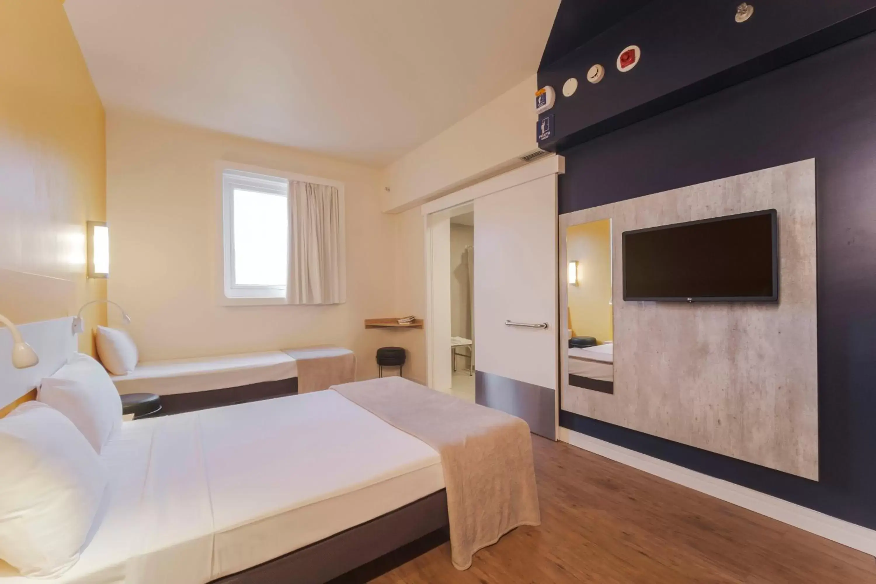 Bed, TV/Entertainment Center in Ibis Budget Farroupilha