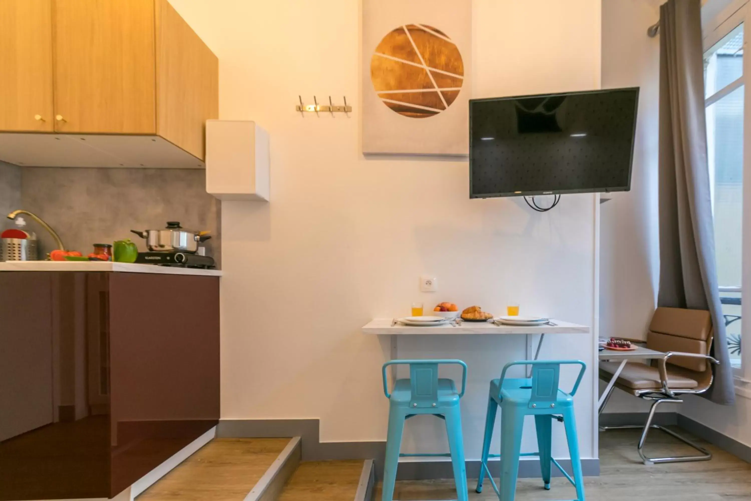 Communal kitchen, TV/Entertainment Center in Apartments WS Haussmann - La Fayette