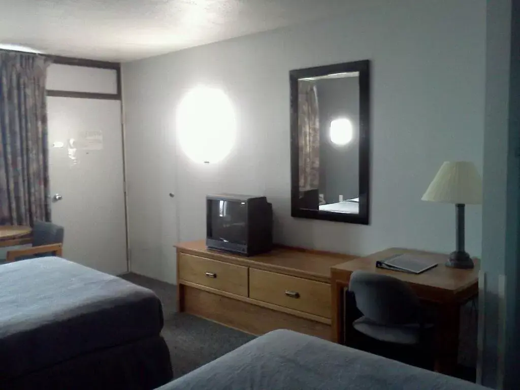 Bed, TV/Entertainment Center in Quail's Nest Inn & Suites