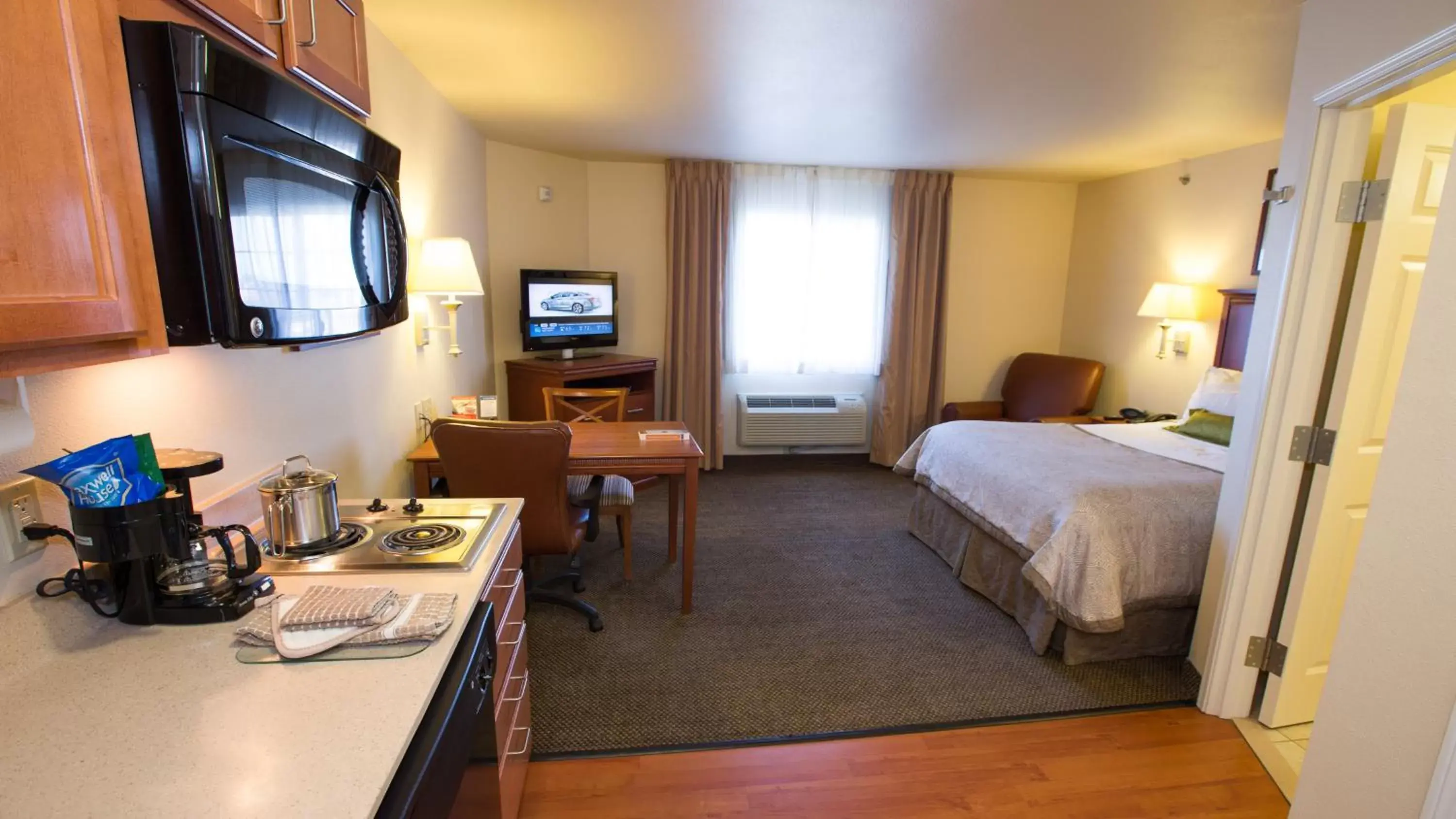 Bedroom, TV/Entertainment Center in Candlewood Suites Joplin, an IHG Hotel