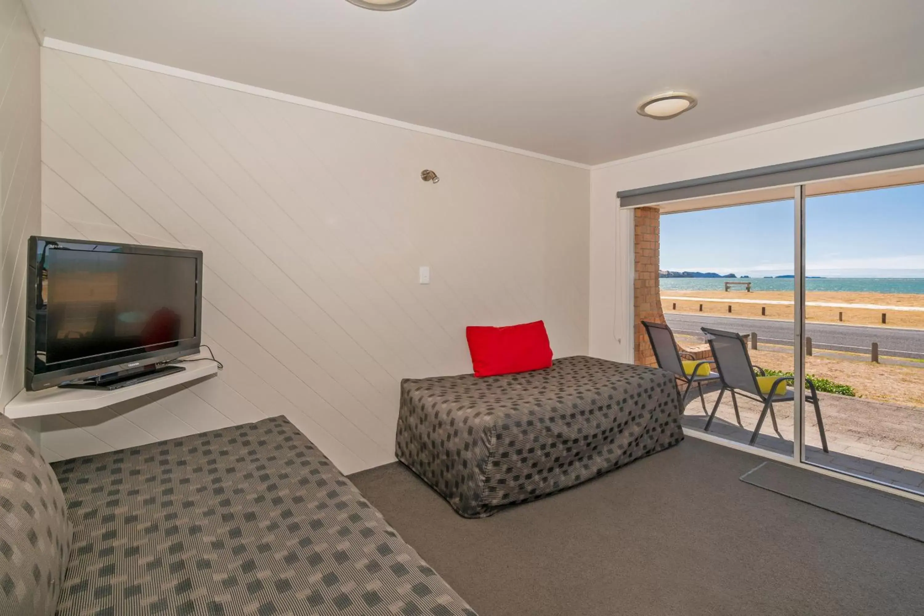 Bed, TV/Entertainment Center in The Oceanside Motel