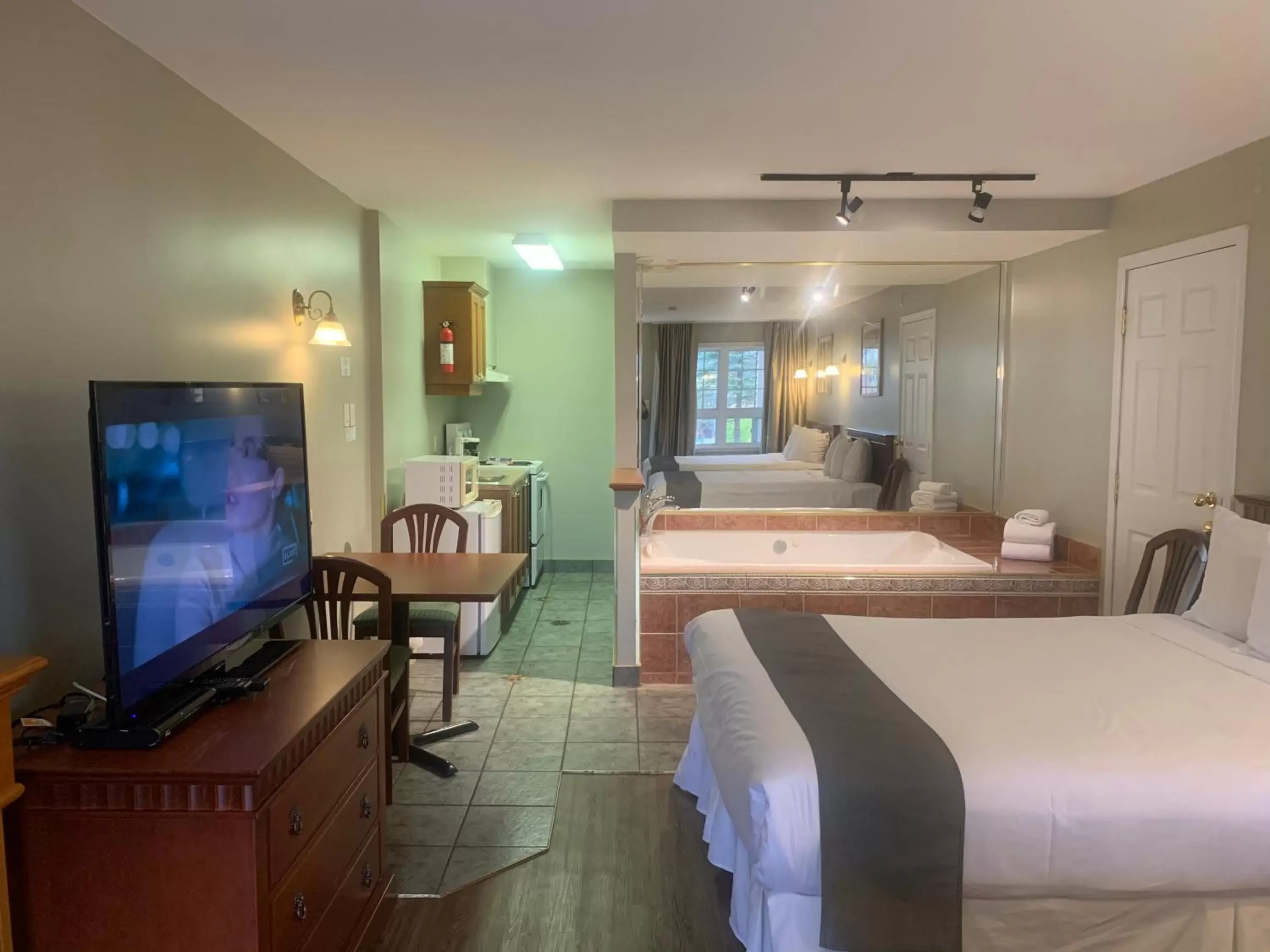 Kitchen or kitchenette, TV/Entertainment Center in Hotel and Suites Les Laurentides