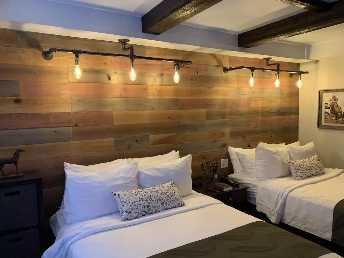 Bed in Cedar Stables Inn & Suites