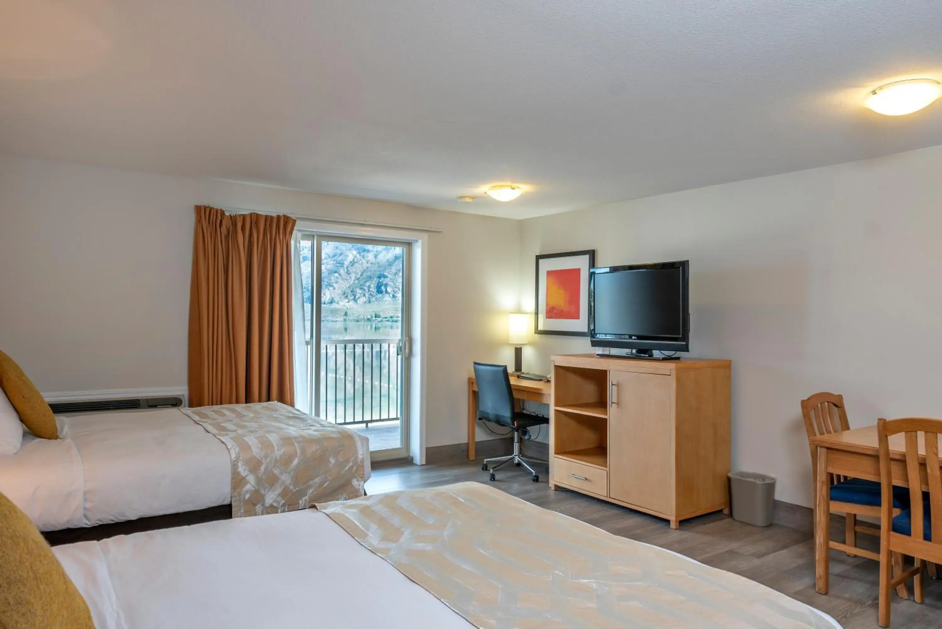 Bed, TV/Entertainment Center in Coast Osoyoos Beach Hotel