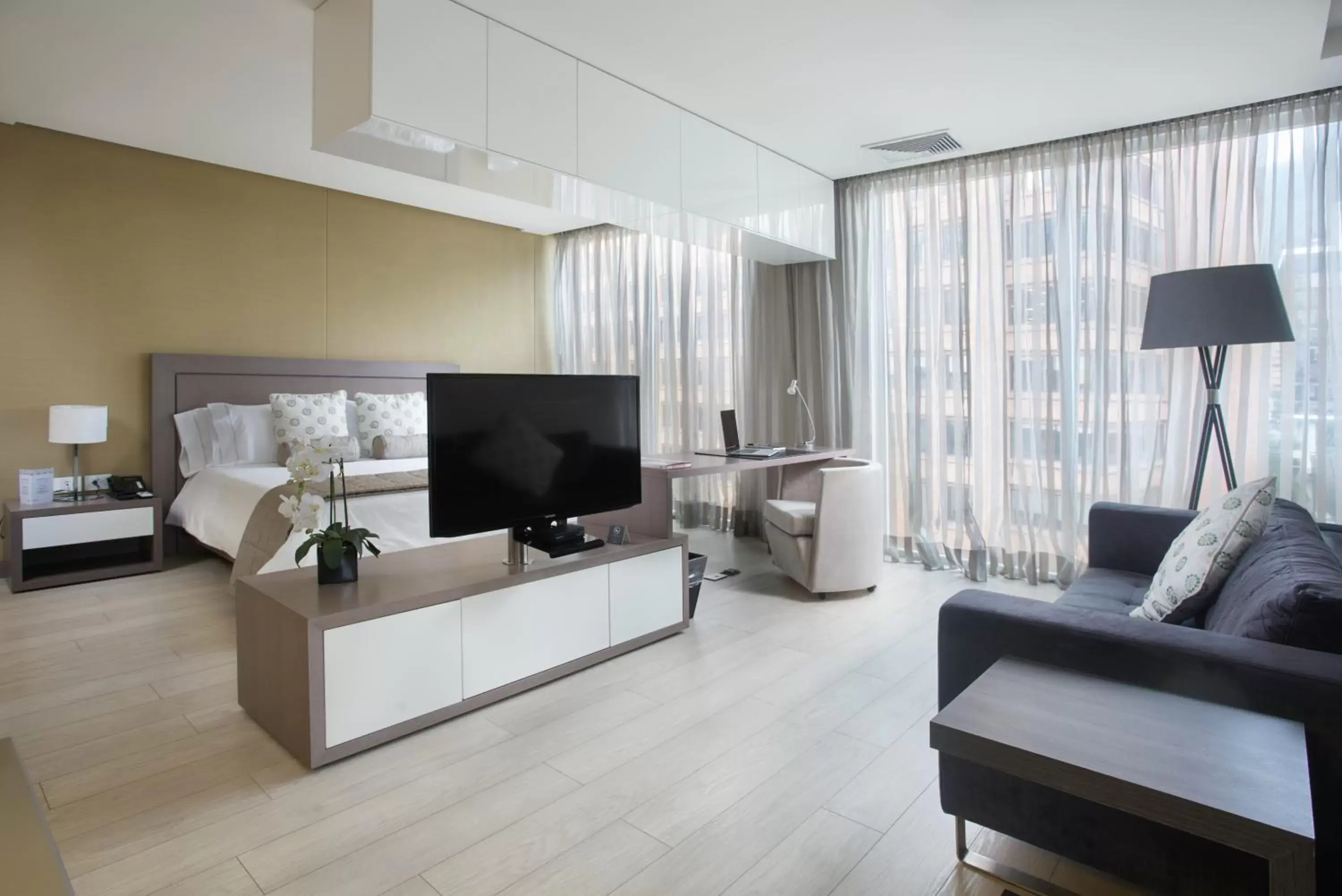 Bed, TV/Entertainment Center in Hotel 100 Luxury Suites by Preferred