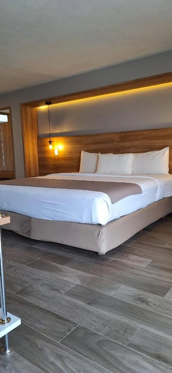 Bed in La Posada Hotel y Suites