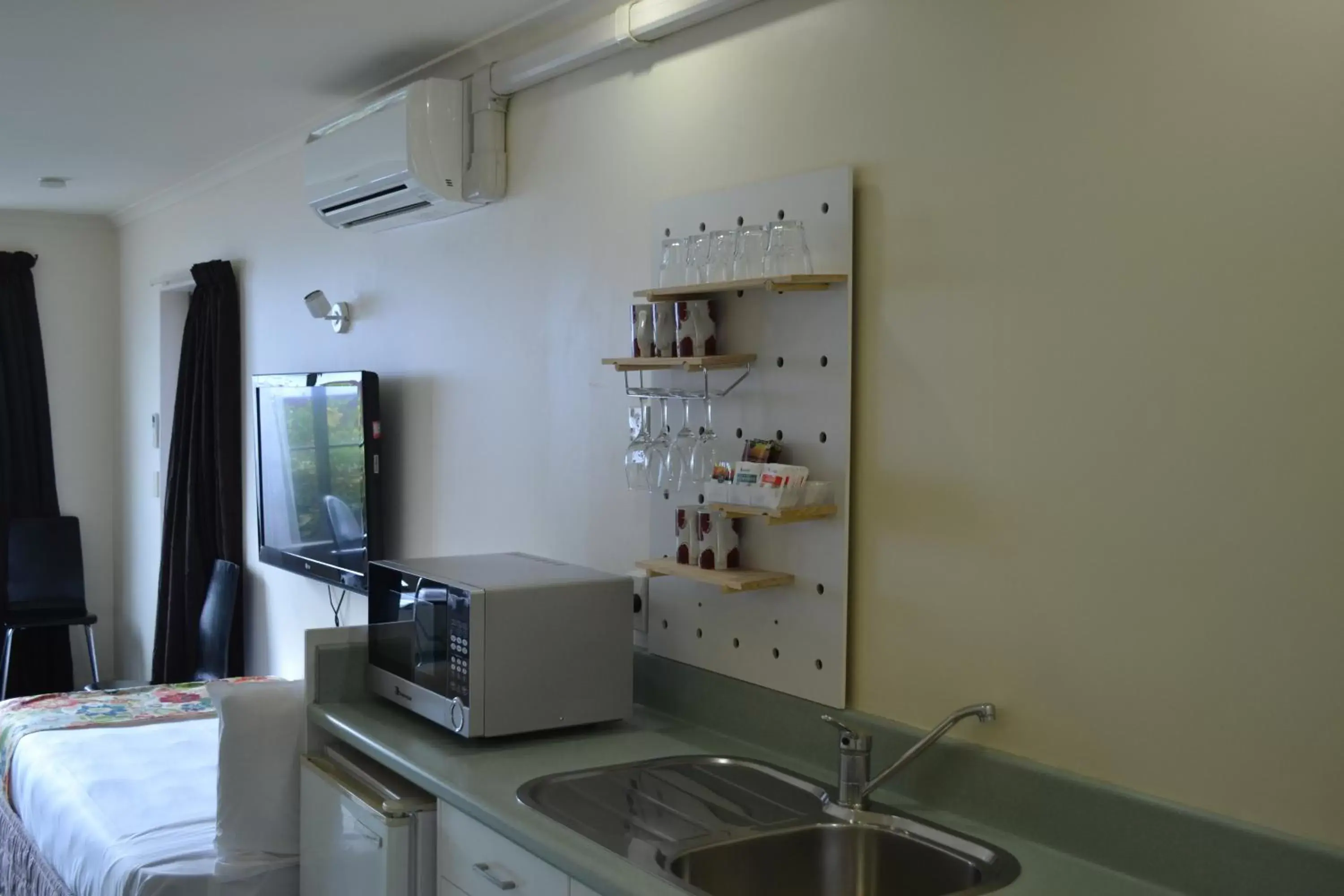 Kitchen or kitchenette, TV/Entertainment Center in Colonial Lodge Motel