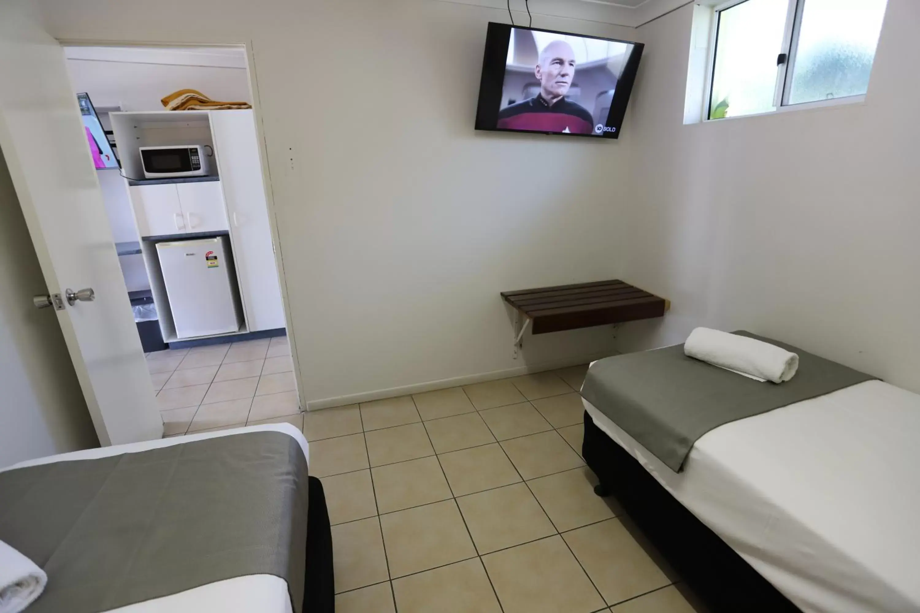 Bed, TV/Entertainment Center in Tropic Coast Motel