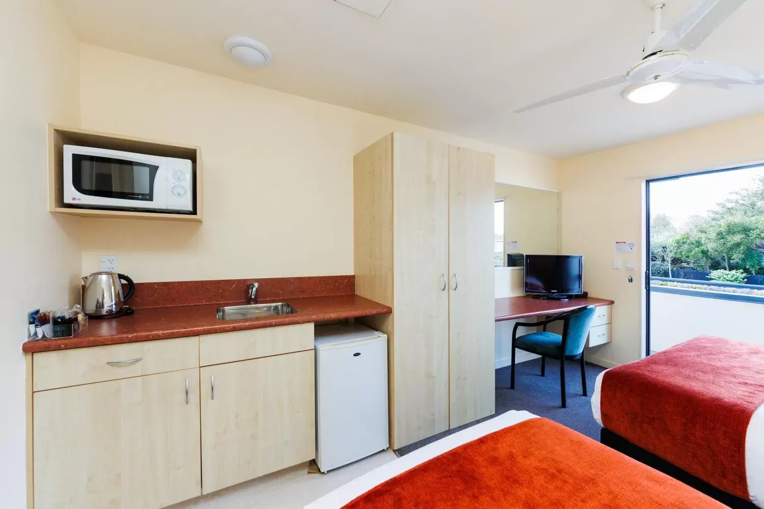 Kitchen or kitchenette, TV/Entertainment Center in Bella Vista Motel Palmerston North