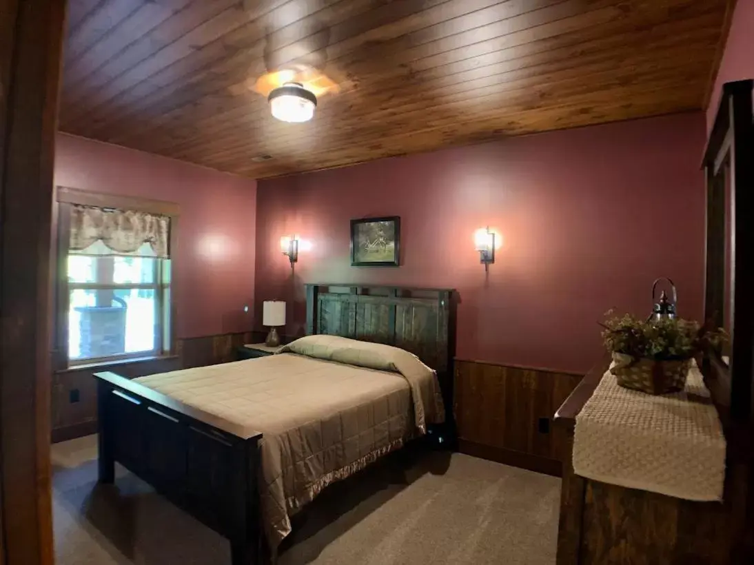 Bed in Sojourner's Lodge & Log Cabin Suites