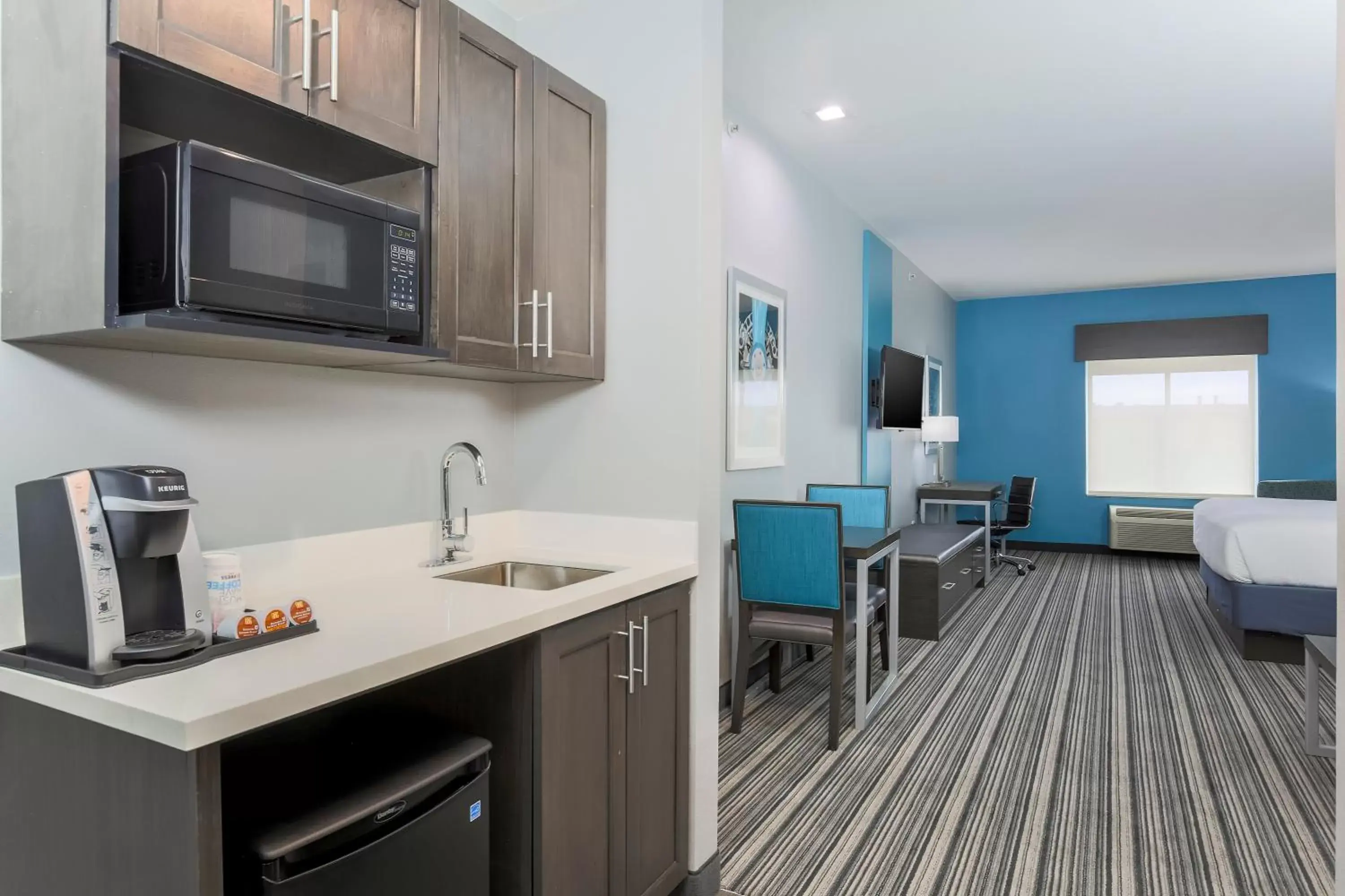 Bedroom, Kitchen/Kitchenette in Holiday Inn Express & Suites Houston - Hobby Airport Area, an IHG Hotel