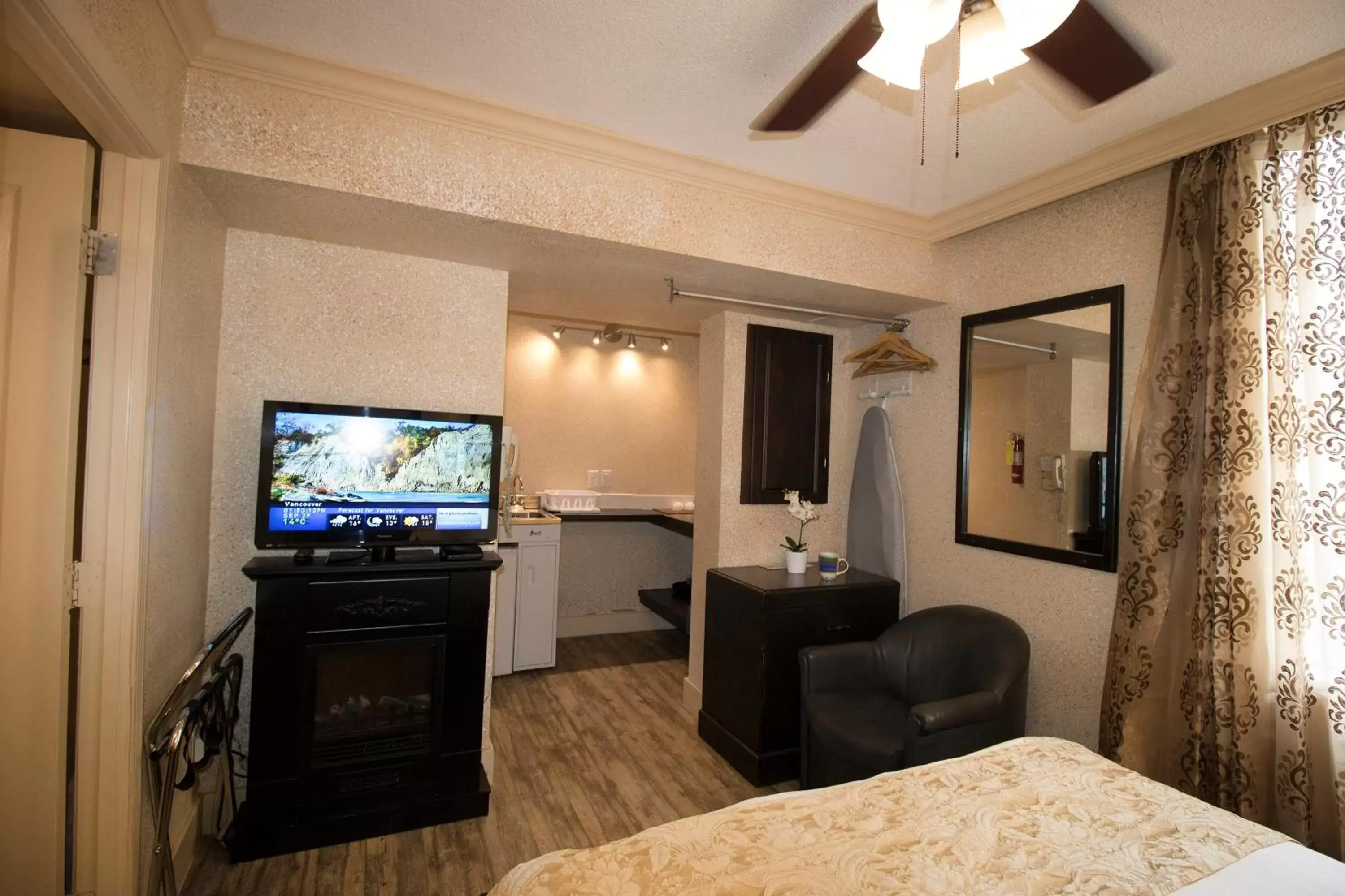 Bed, TV/Entertainment Center in Riviera Divya Sutra Hotel on Robson Downtown Vancouver
