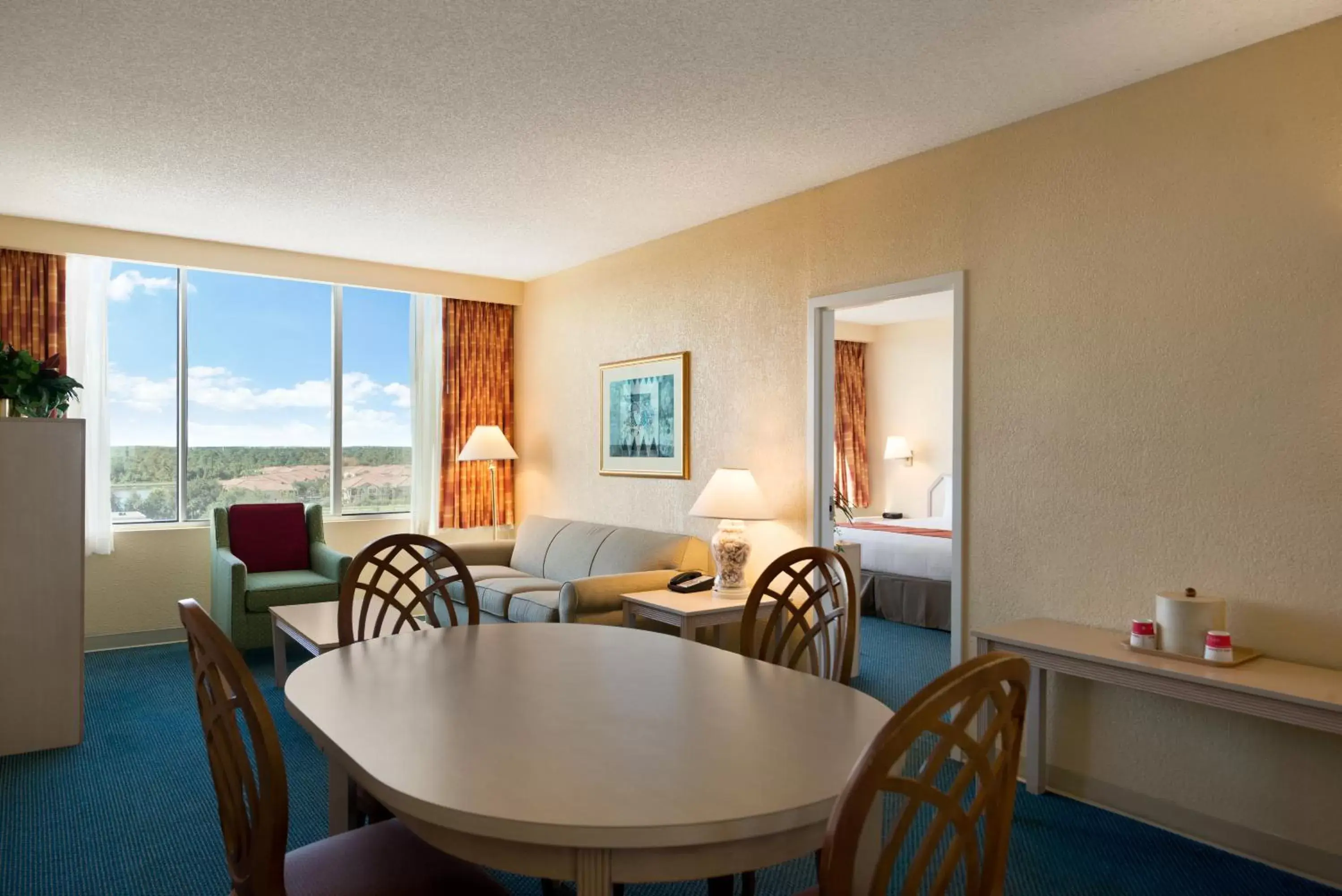 Living room, Dining Area in Ramada by Wyndham Kissimmee Gateway
