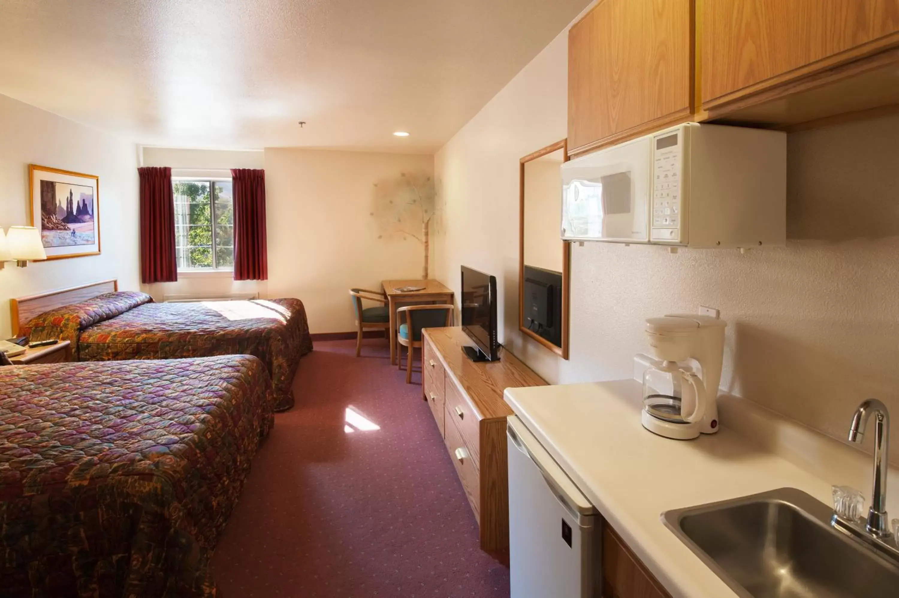 Bed, Kitchen/Kitchenette in Carson City Plaza Hotel