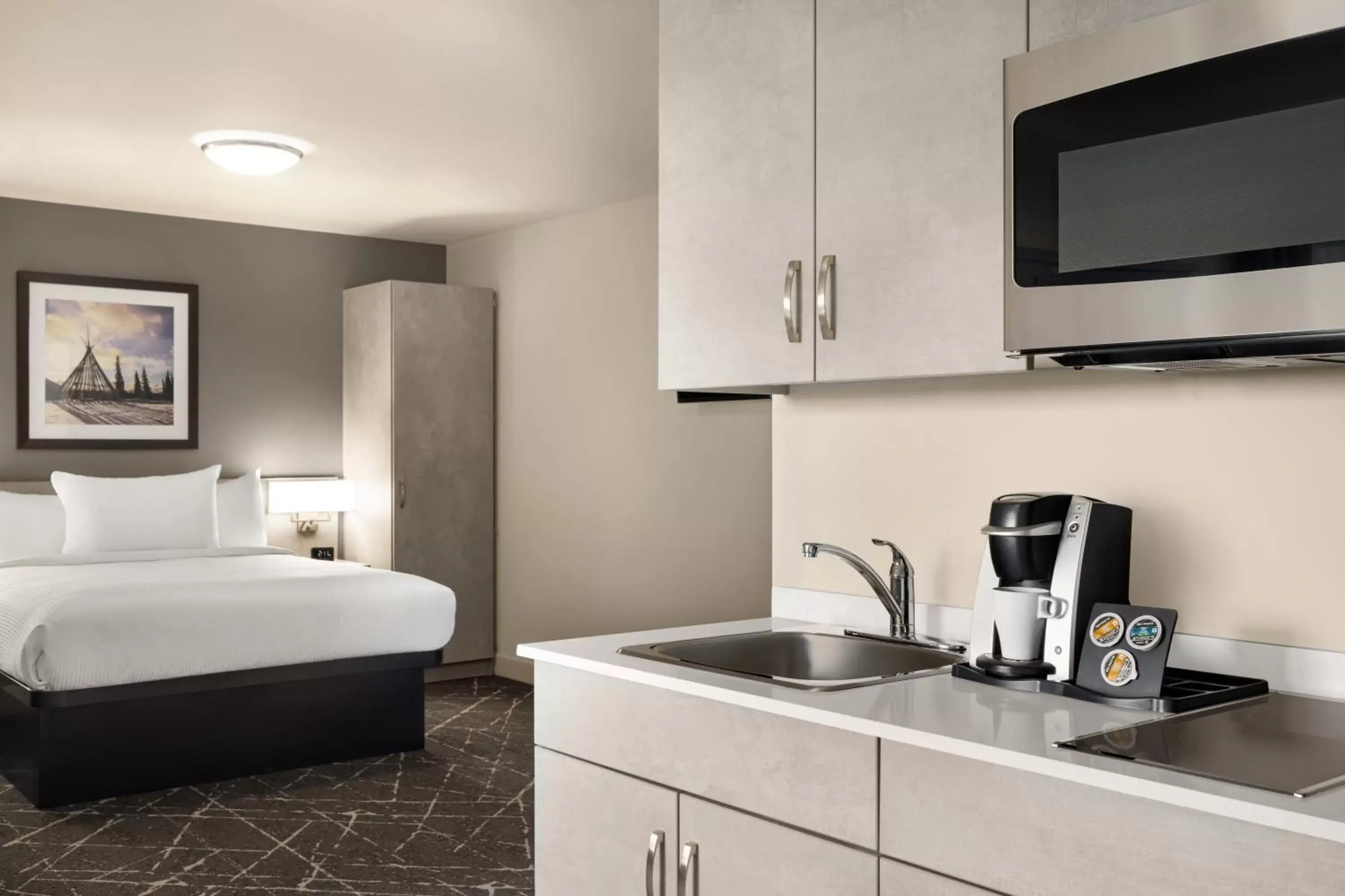 Bed, Kitchen/Kitchenette in Microtel Inn & Suites Montreal Airport-Dorval QC