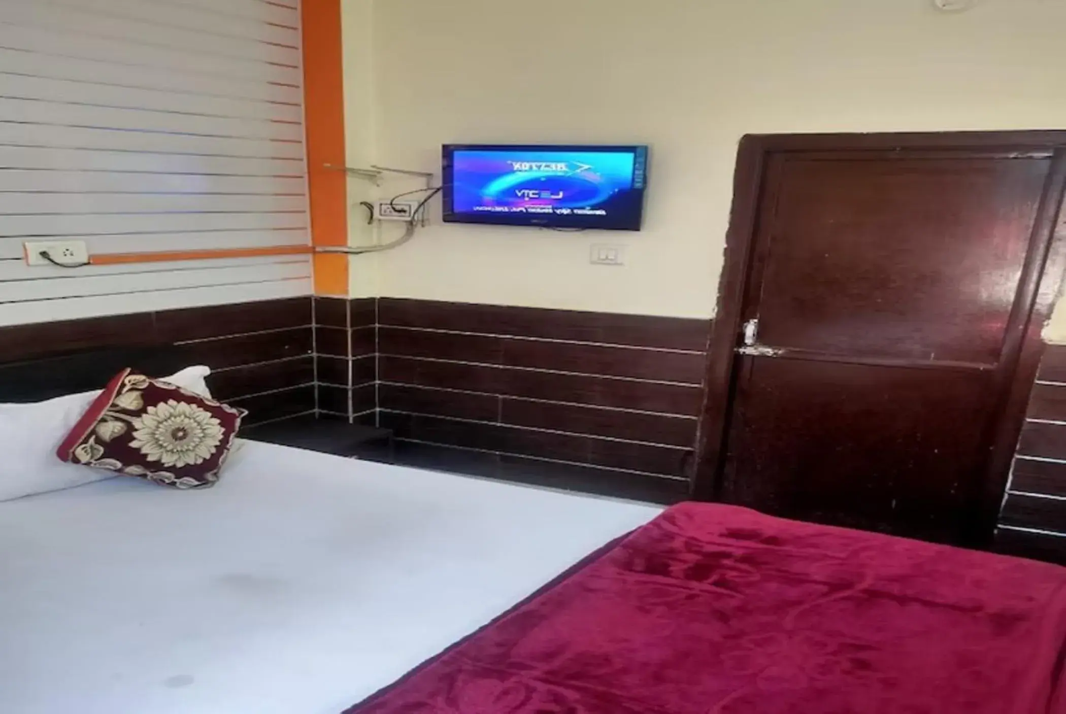 Bed, TV/Entertainment Center in Goroomgo New Ashiyana Palace Varanasi Bed, TV/Entertainment Center in Goroomgo New Ashiyana Palace Varanasi