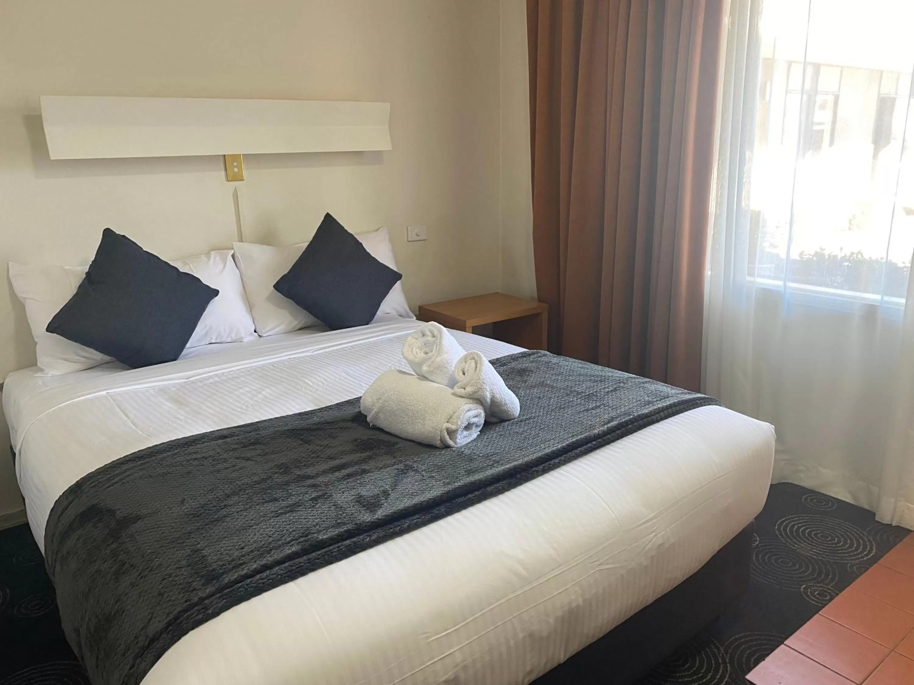 Bed in The Astor Hotel Motel