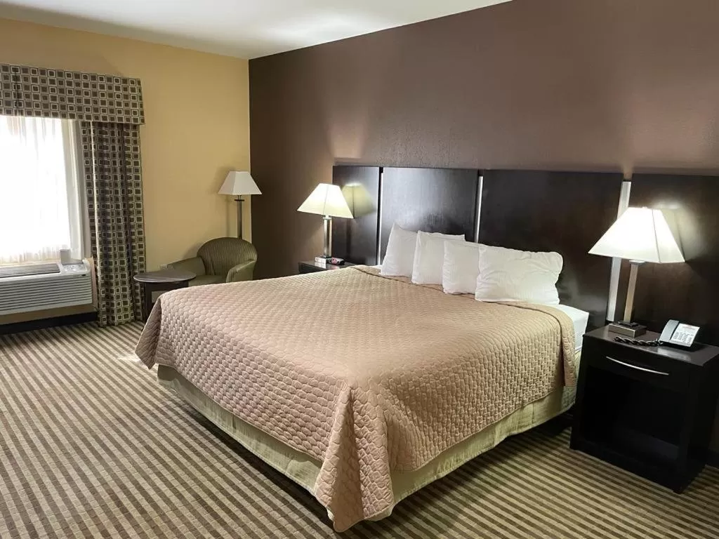Bed in Whitney Inn & Suites