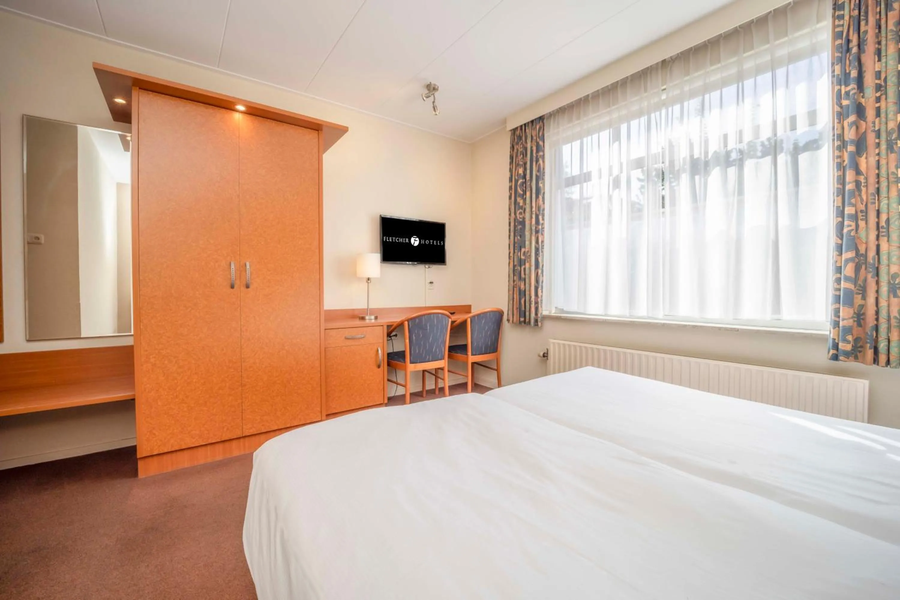 Communal lounge/ TV room, Bed in Fletcher Hotel-Restaurant Waalwijk