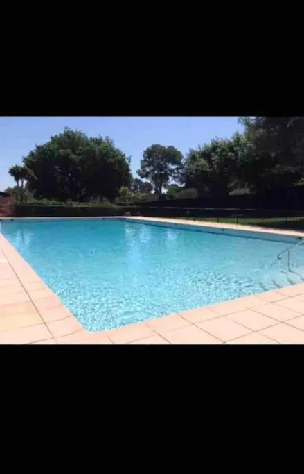 Swimming pool in Charmant appartement dans un domaine avec piscine