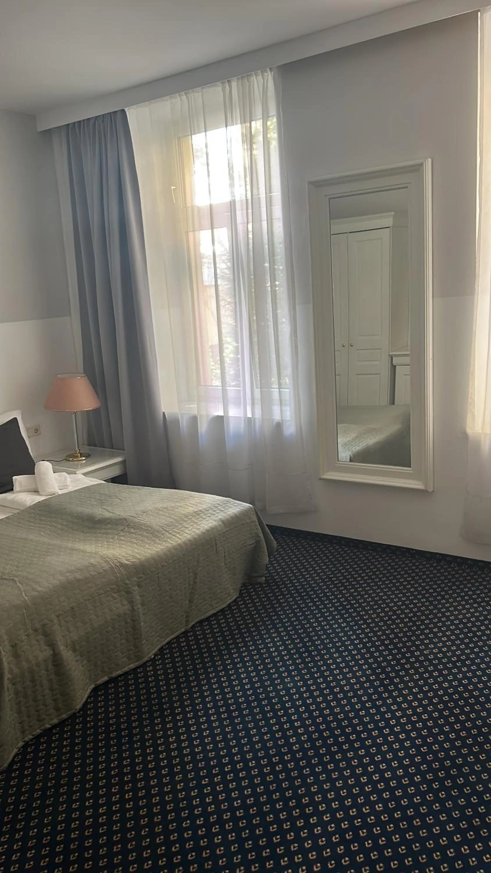 Bed in Self-Check-In Hotel Adlon