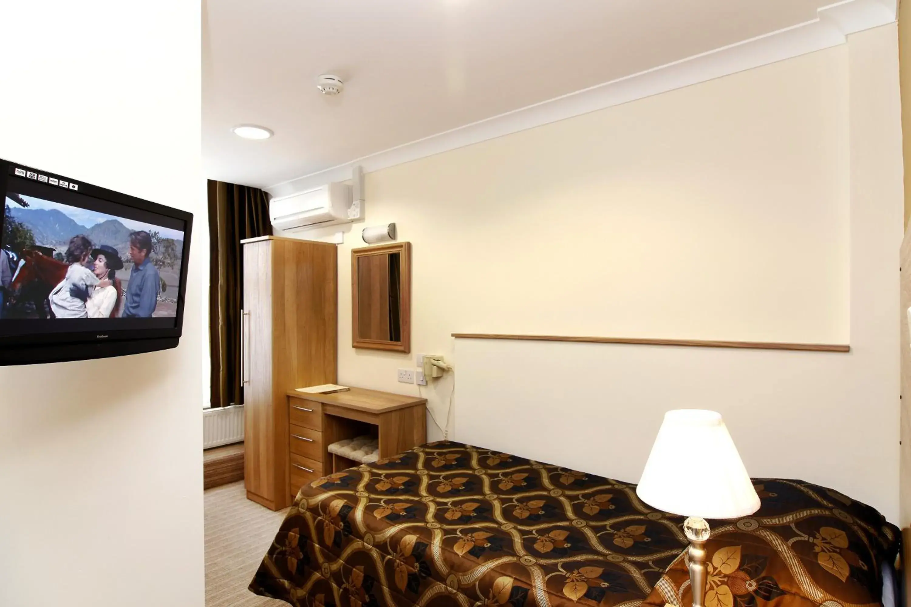 Bed, TV/Entertainment Center in Russell Court Hotel