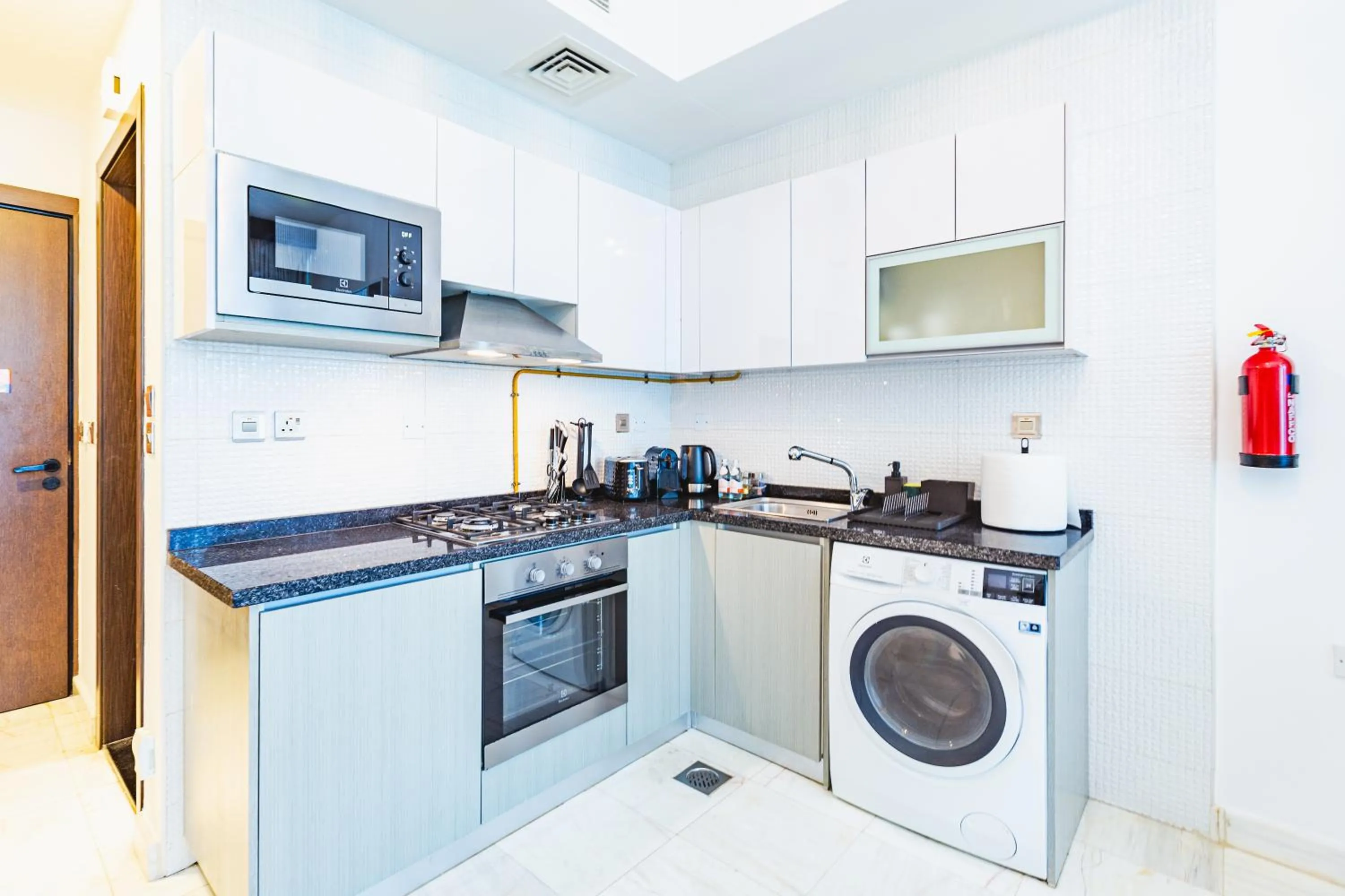 Kitchen or kitchenette in Waves Holiday Homes - Chic Studio With Balcony Overlooking City Views
