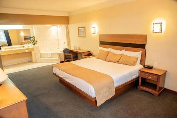 Bed in American Inn Hotel & Suites Parral