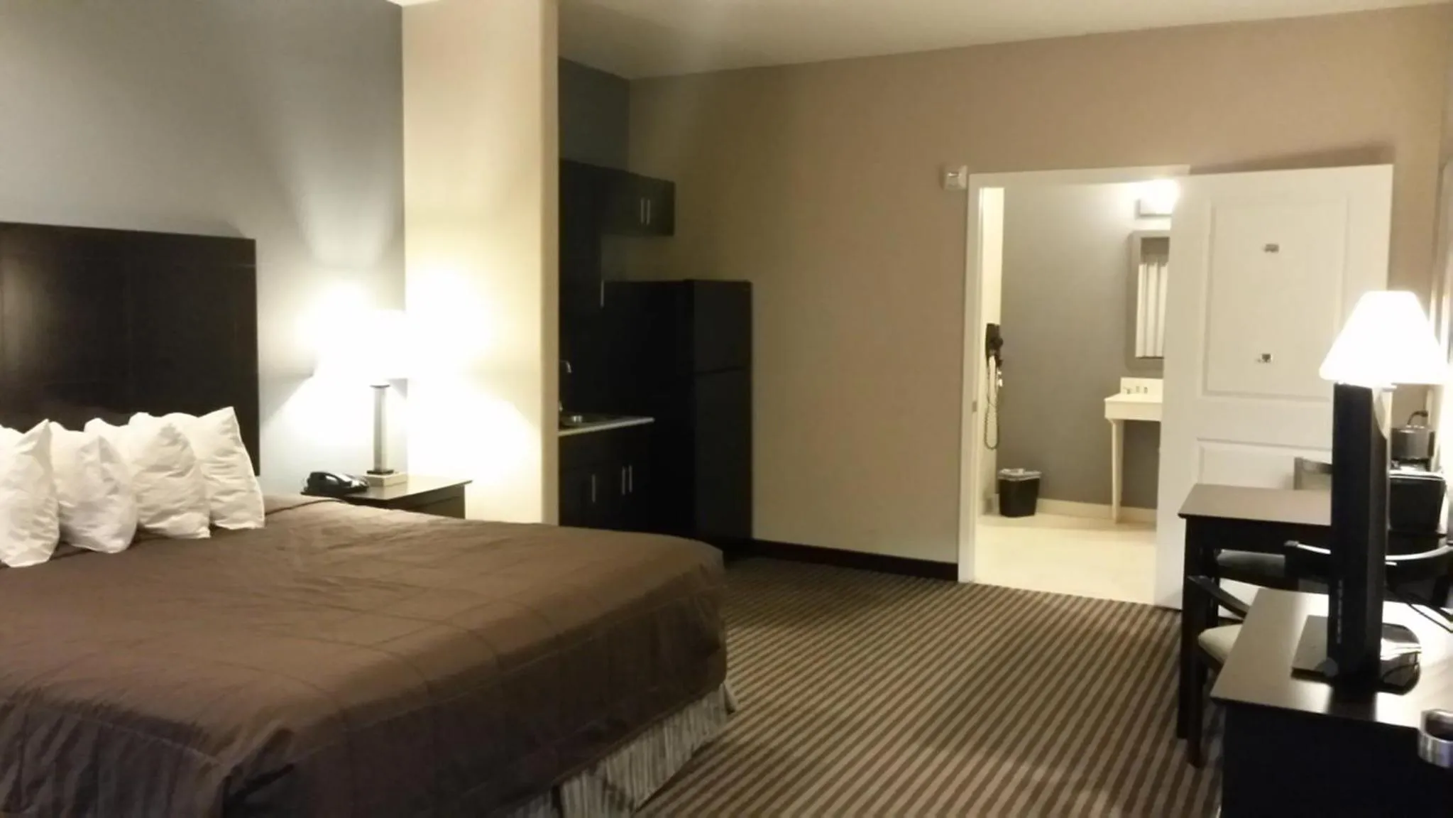 Kitchen or kitchenette, Bed in Atria Inn & Suites